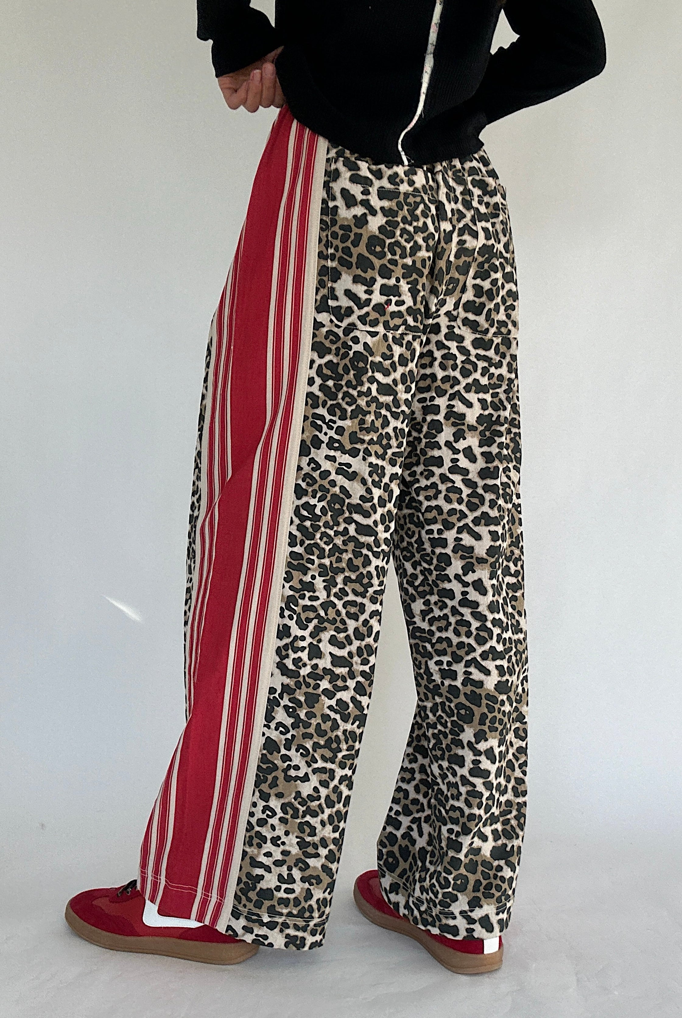 Leopard print pants with red stripes on a white background