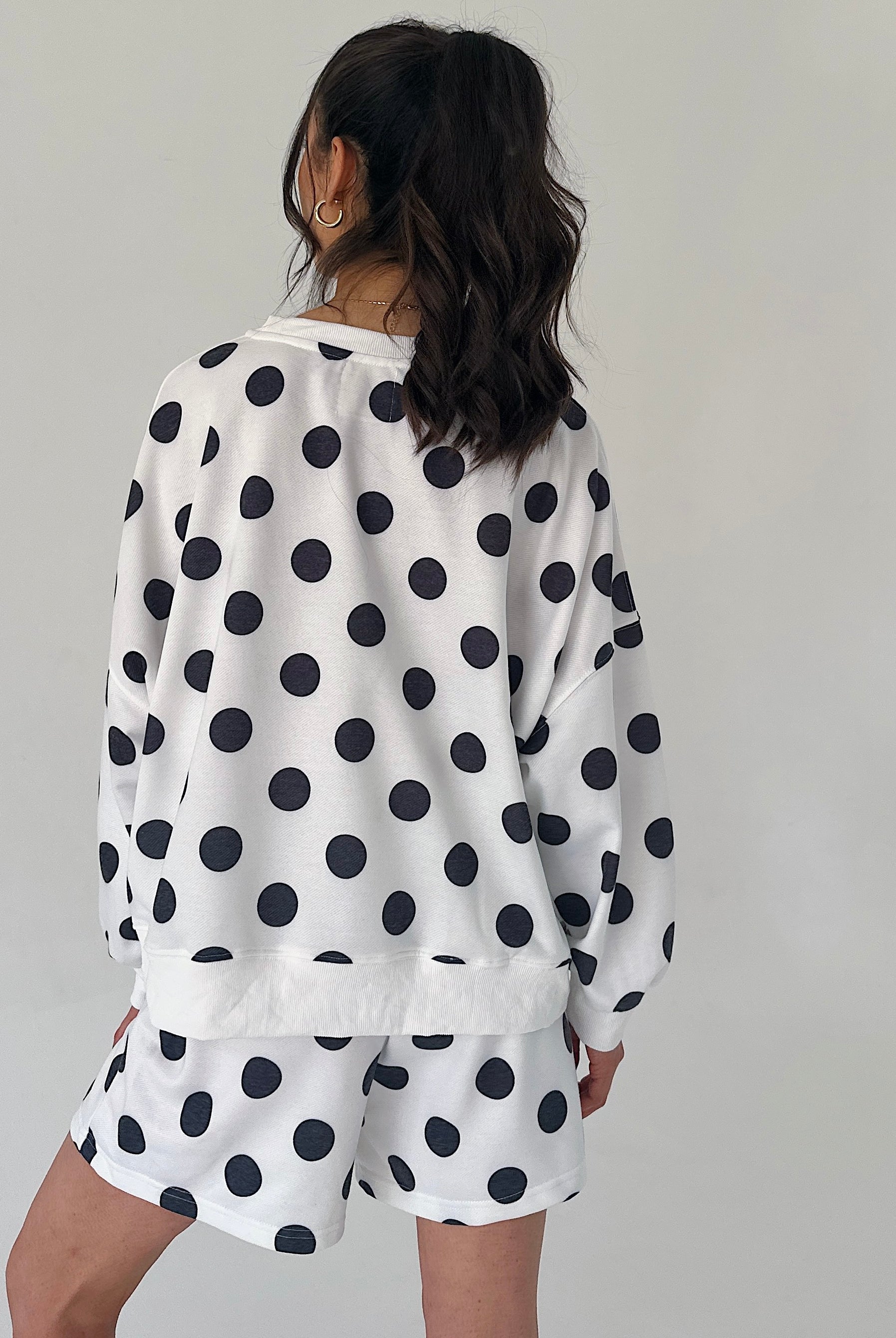Person wearing a polka dot outfit with a white background