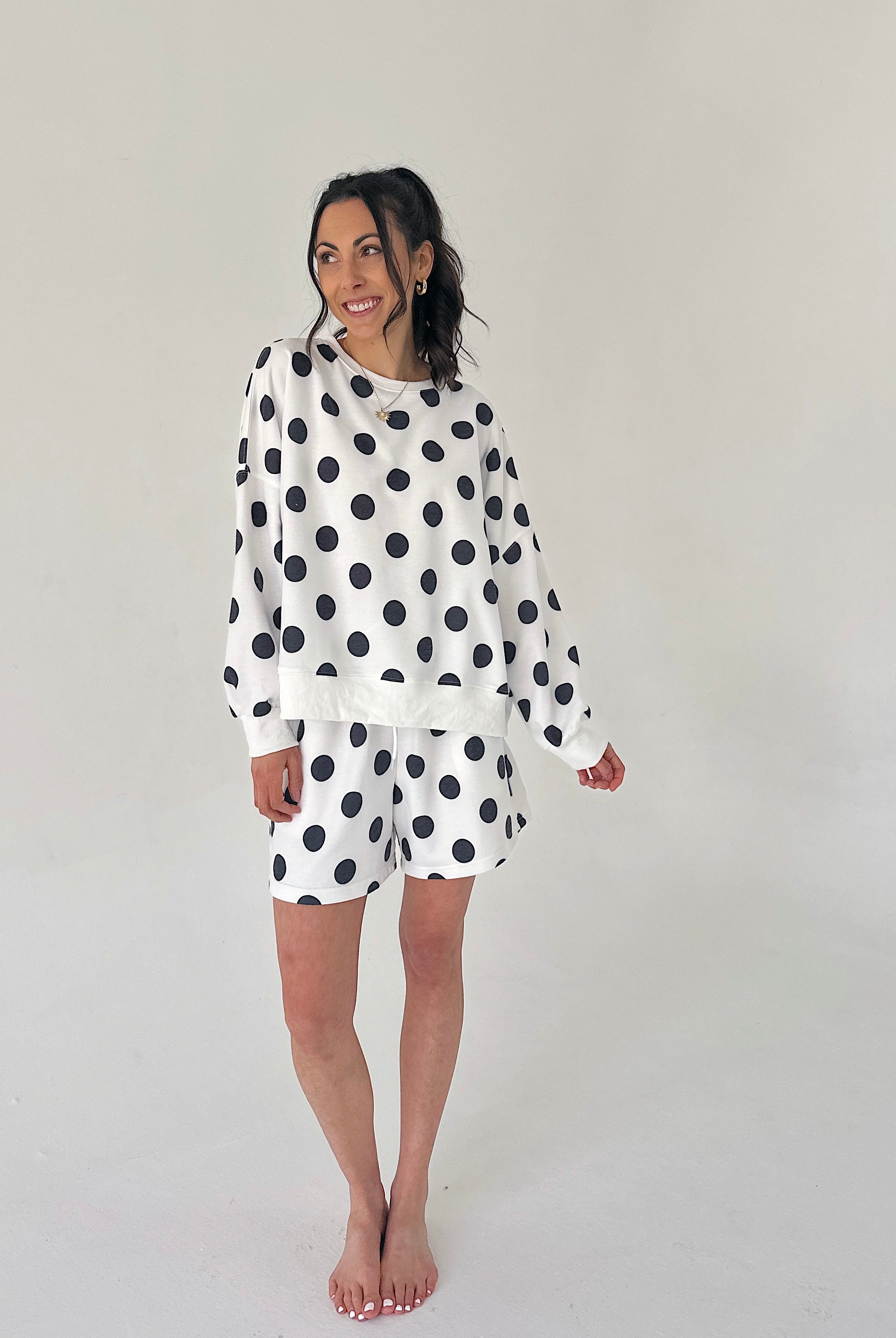 Woman wearing a polka dot set on a plain background