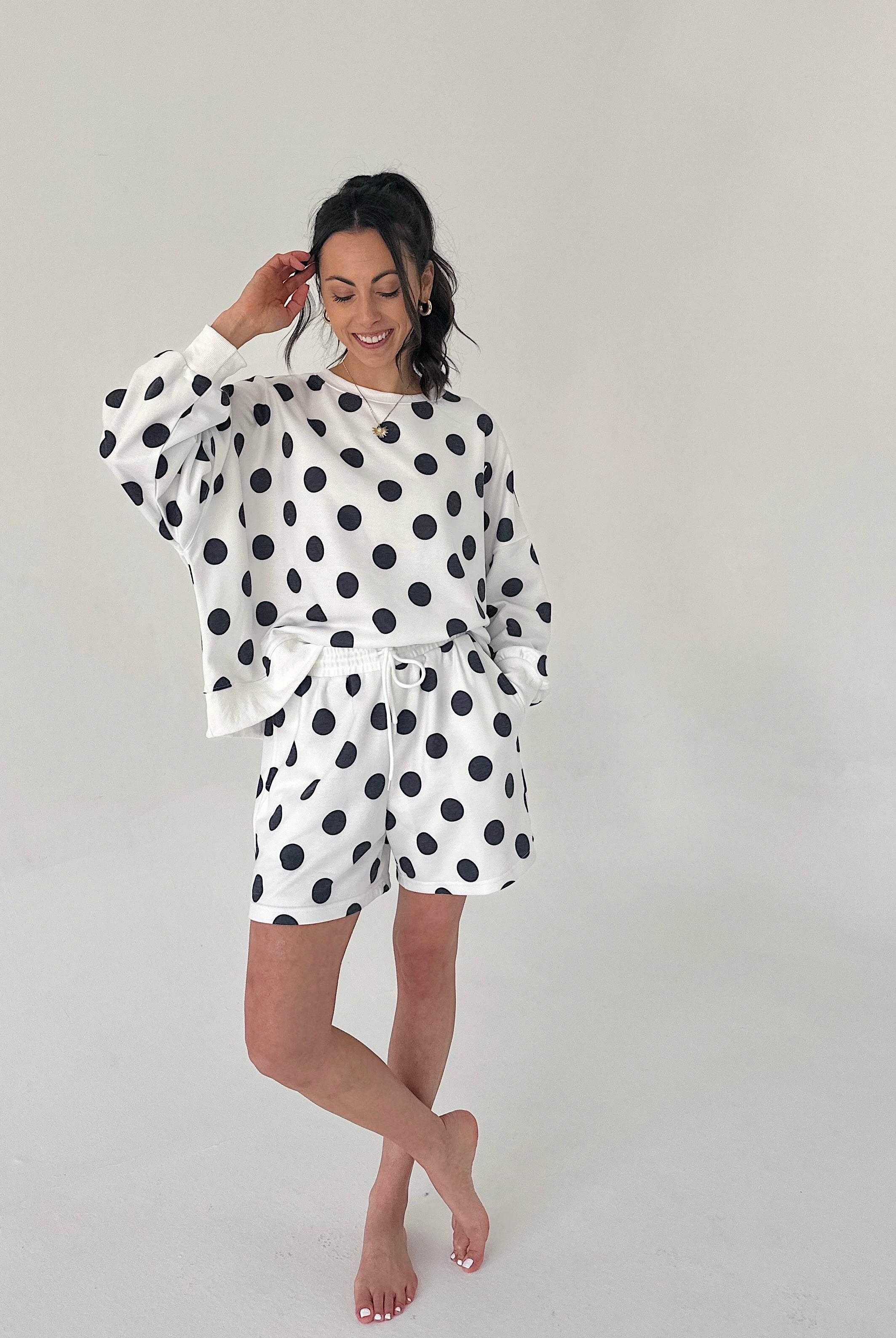Woman wearing a polka dot outfit on a plain background