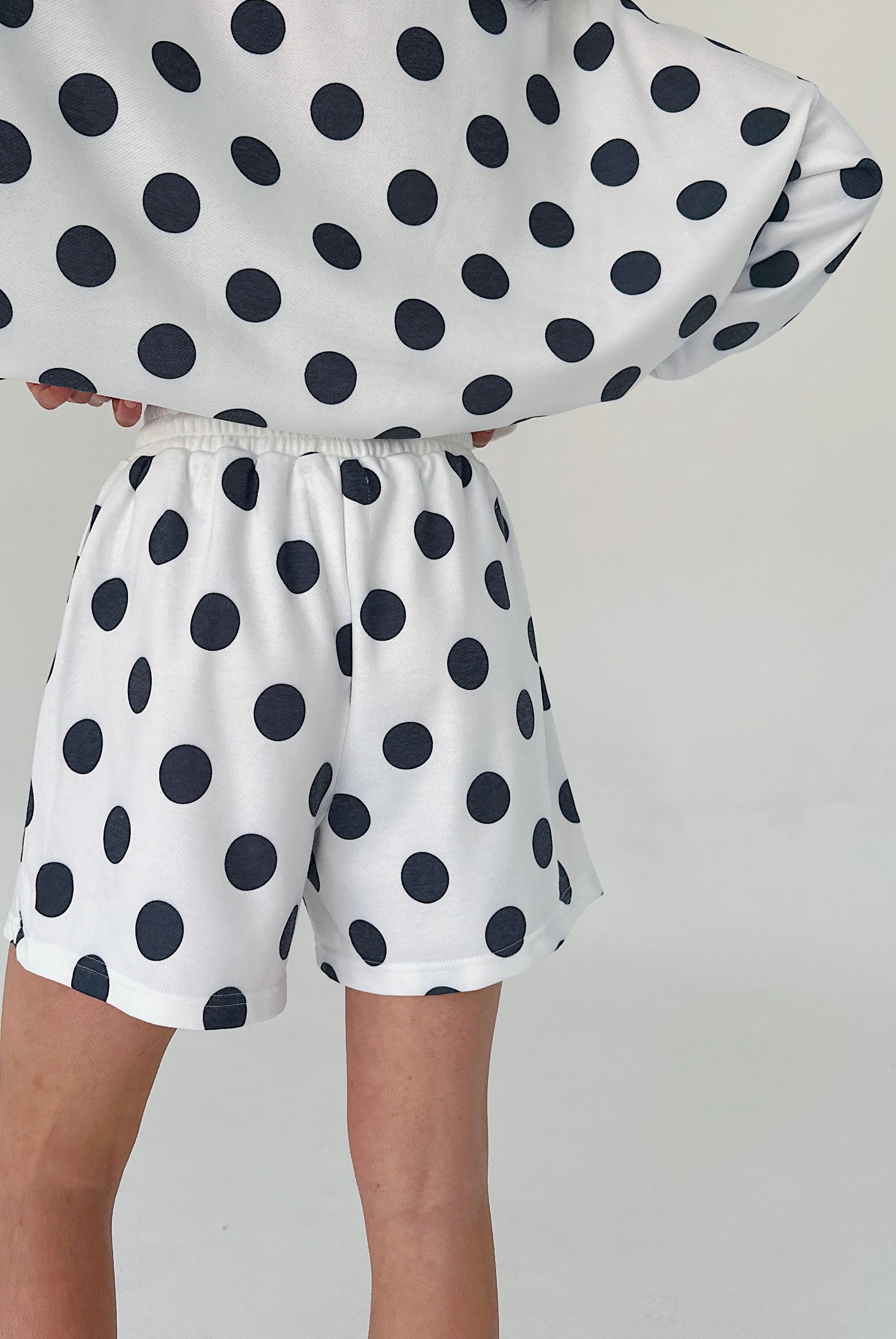 Person wearing a polka dot outfit with a white background