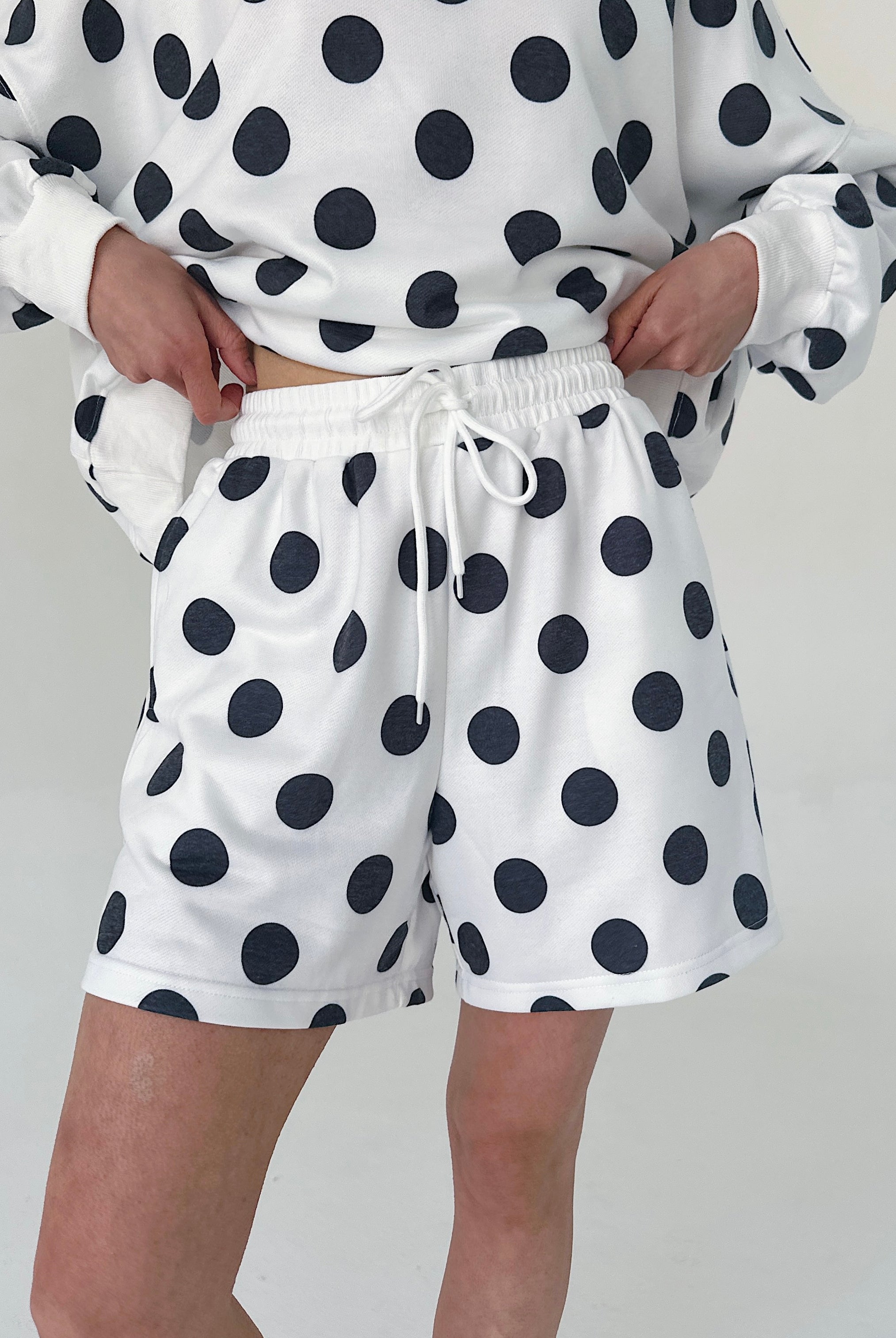 Person wearing a polka dot outfit with a white background