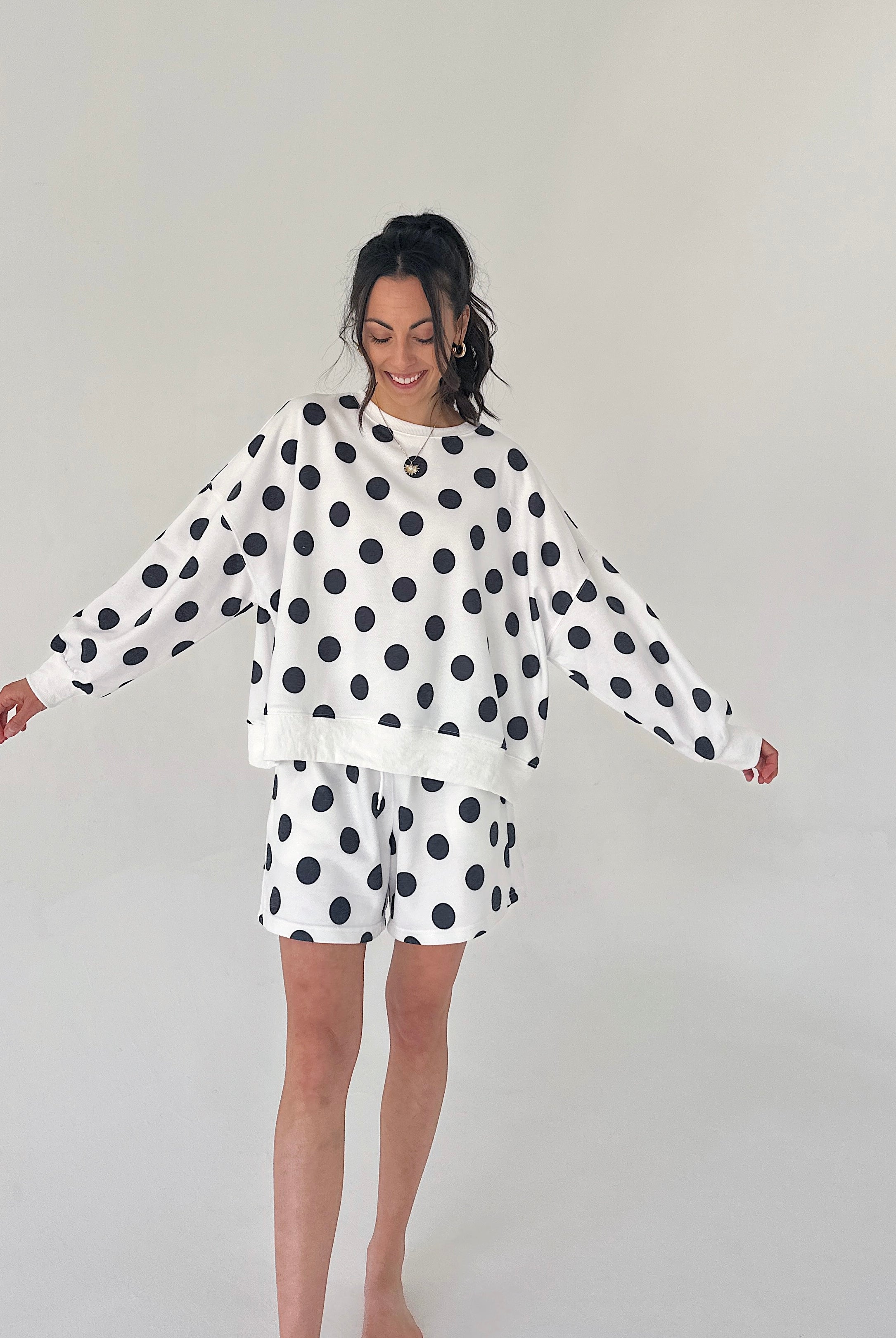 Woman wearing a polka dot outfit on a plain background