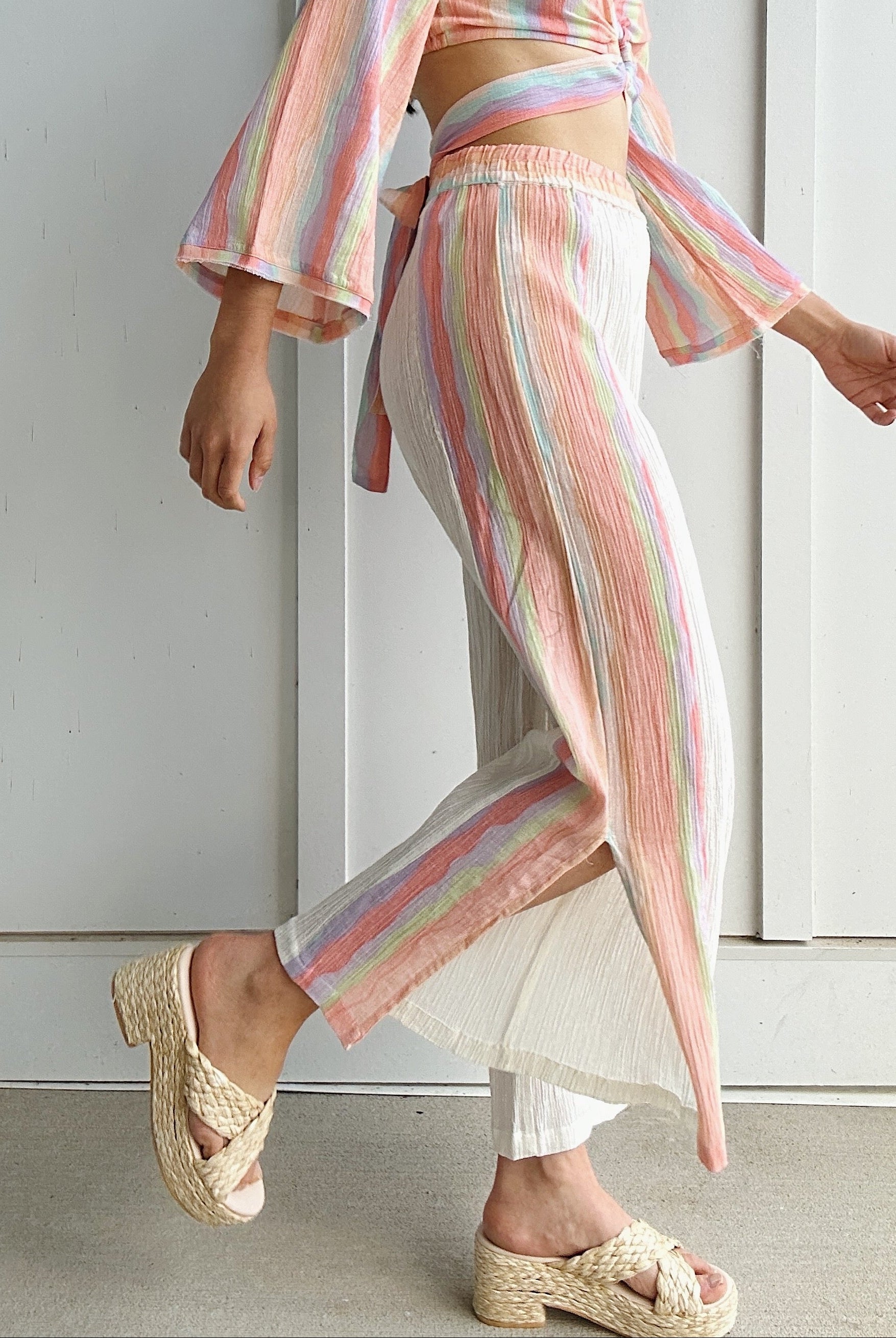 woman wearing wide leg light weight pants with colorful side stripes