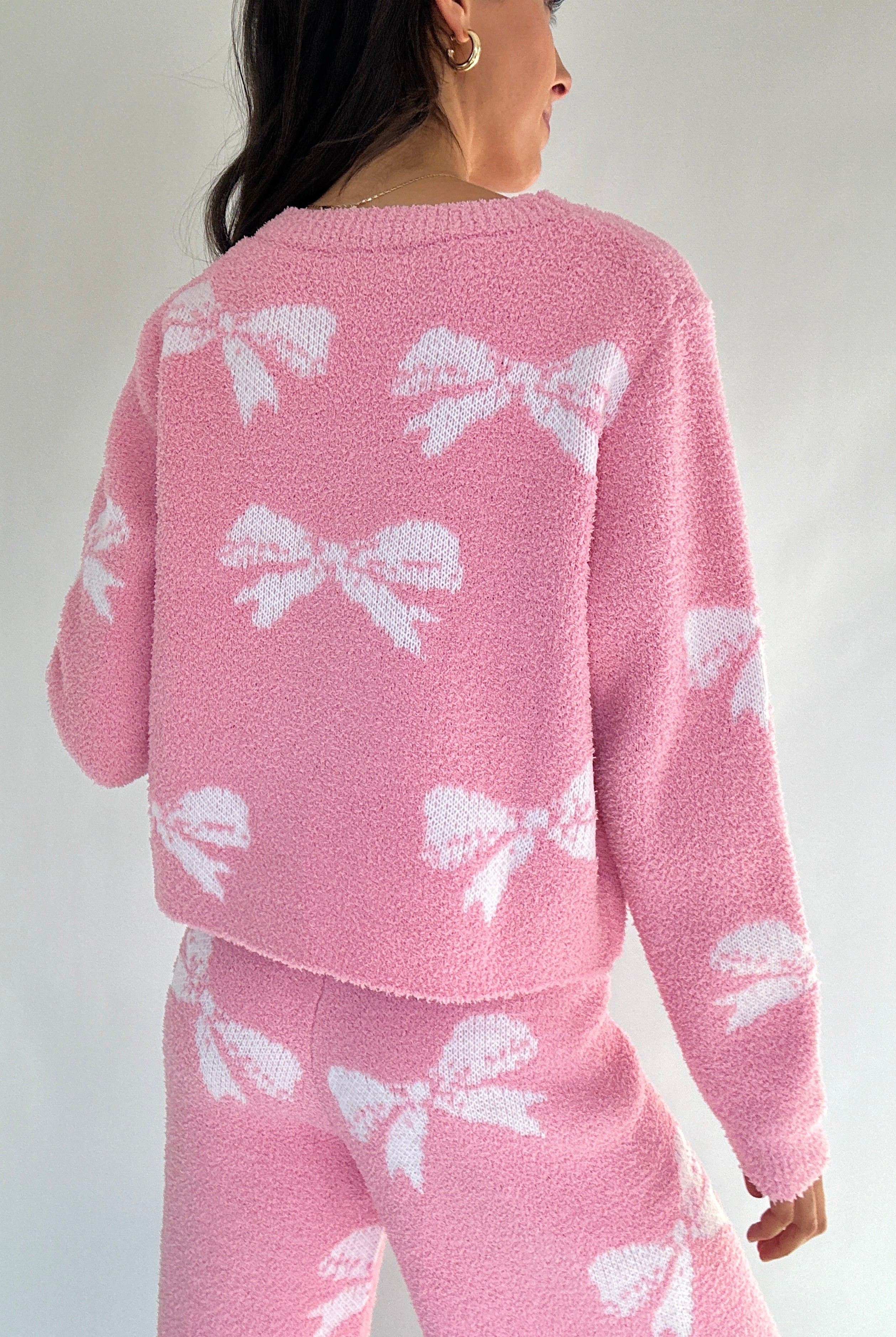 Pink lounge set with white bow patterns on a plain background showing back of top