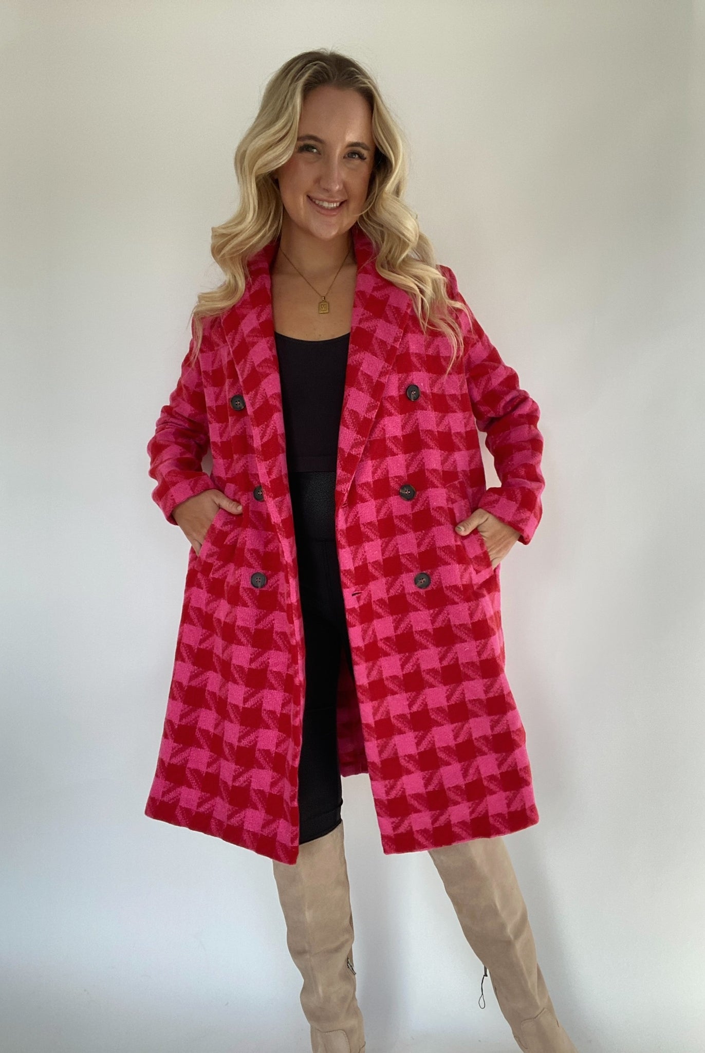 Woman with hands in pockets of red and pink houndstooth tweed coat