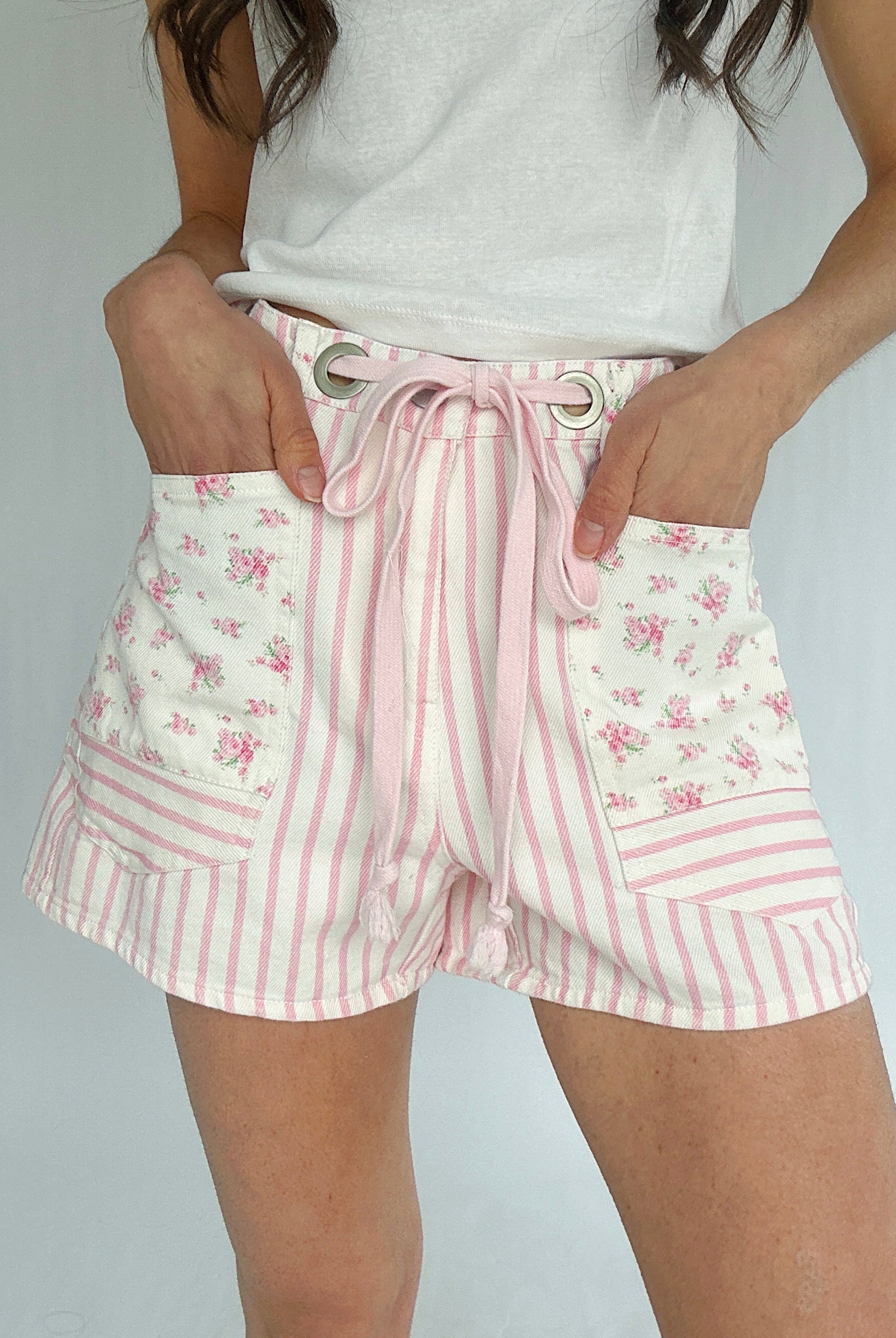 Shorts with pink floral and striped pattern on a plain background