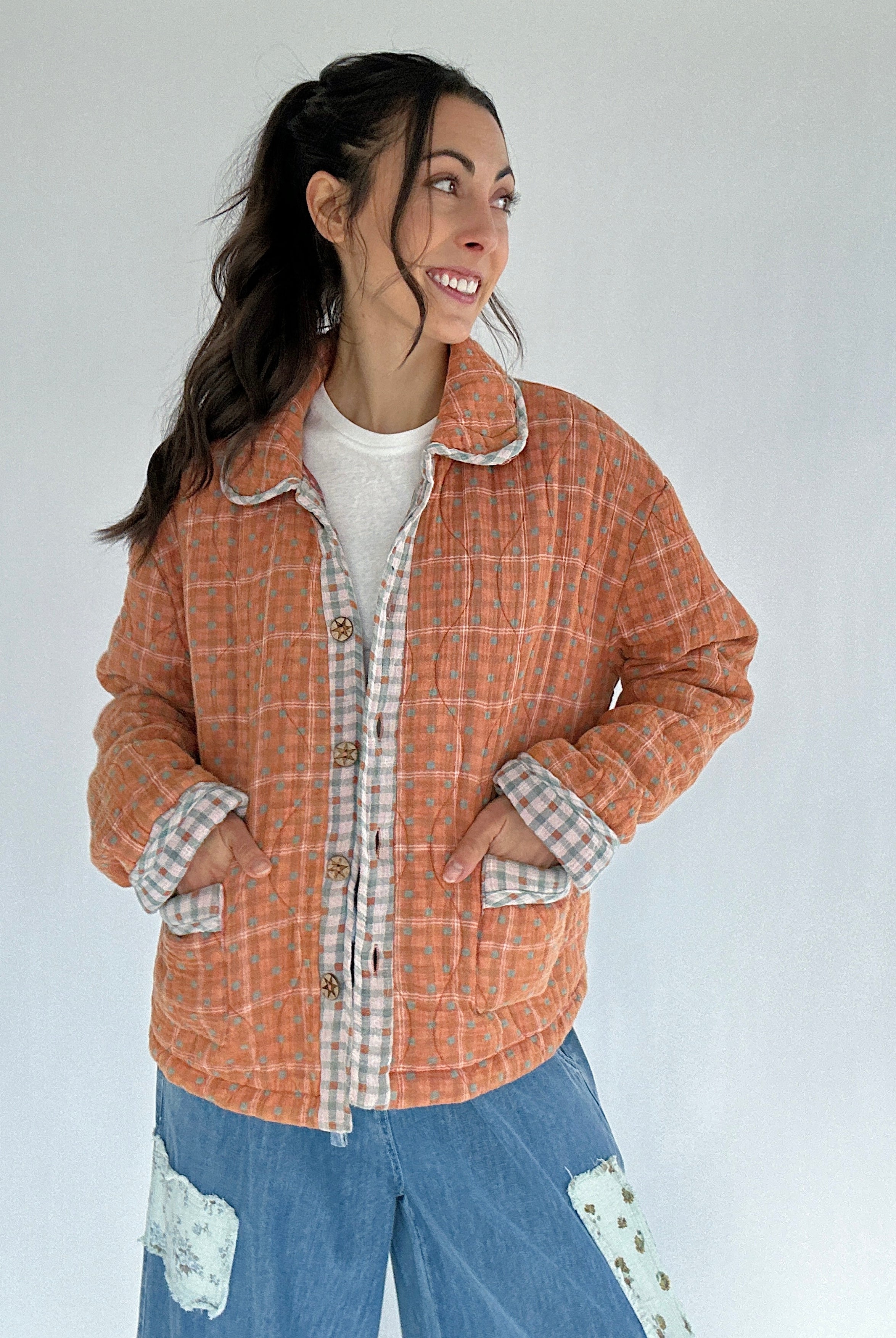 Woman wearing a plaid jacket with a white background