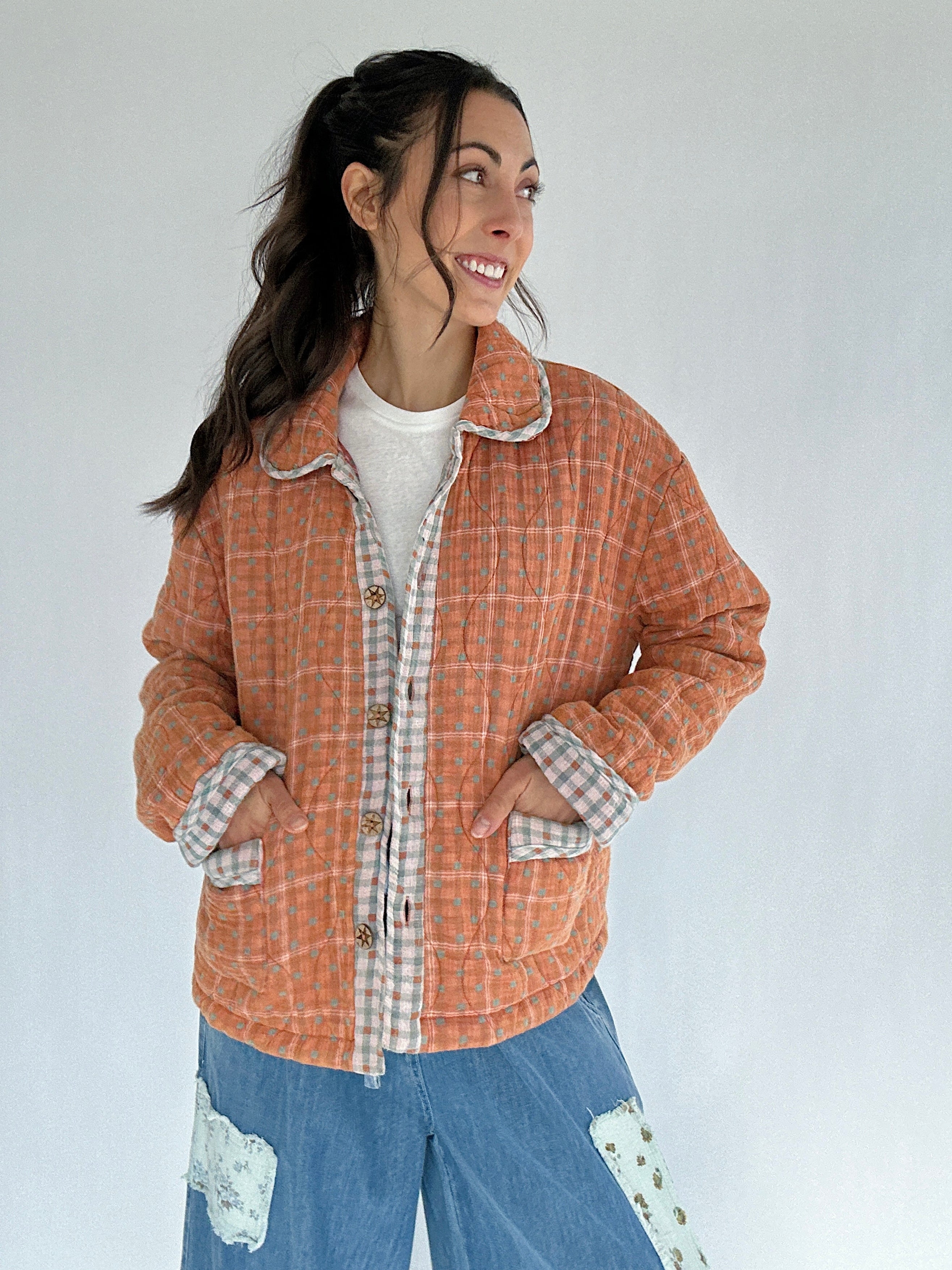 Woman wearing a plaid jacket with a white background
