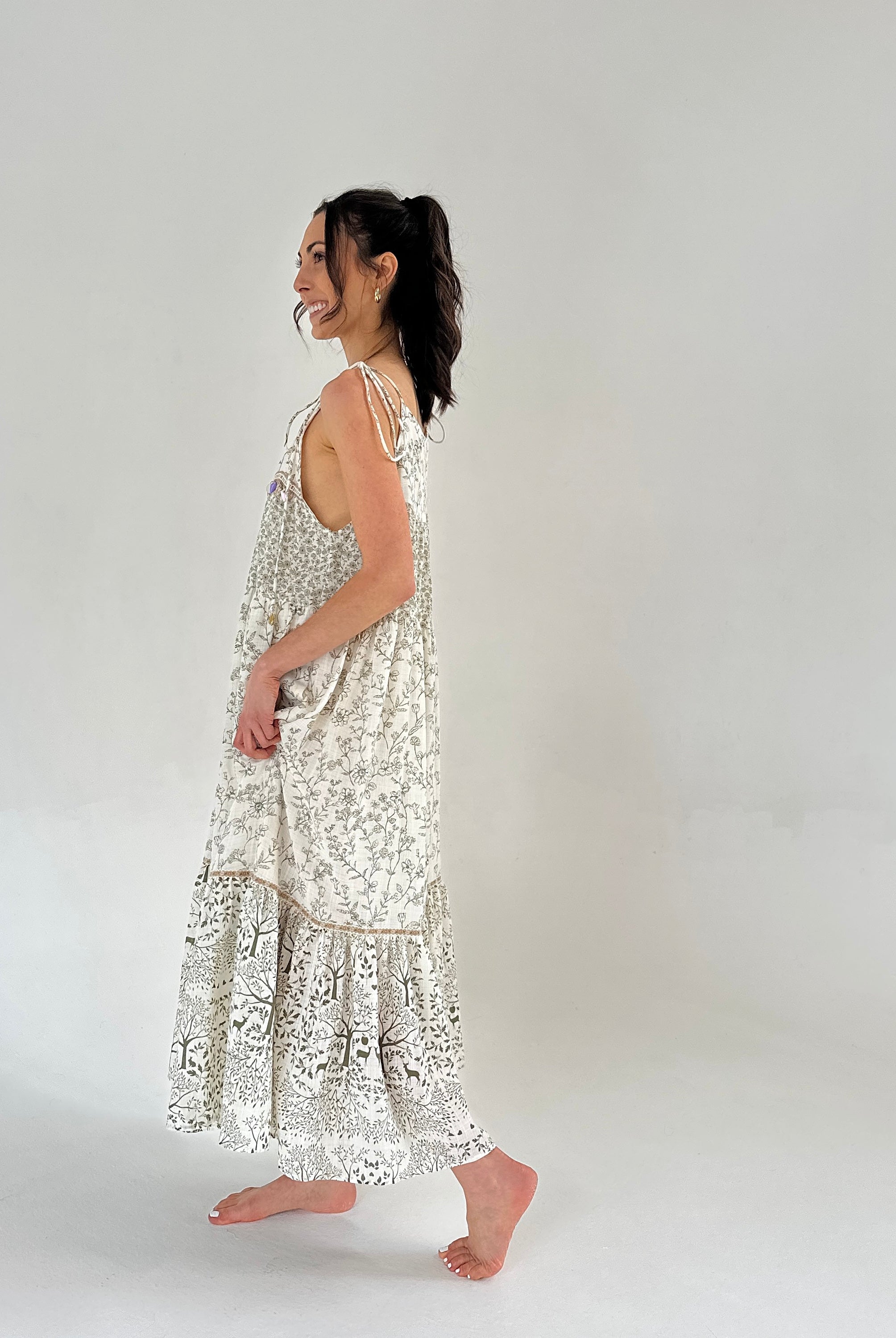 Woman wearing a white floral dress with a plain background