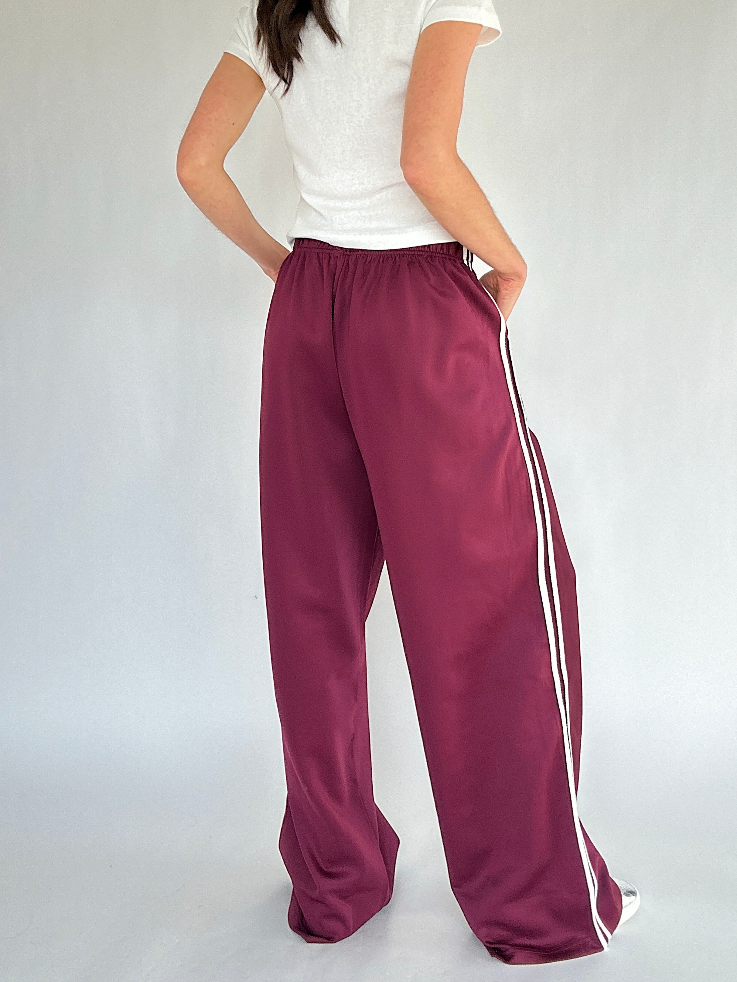 Maroon wide-leg pants with white stripes on a plain background showing the back