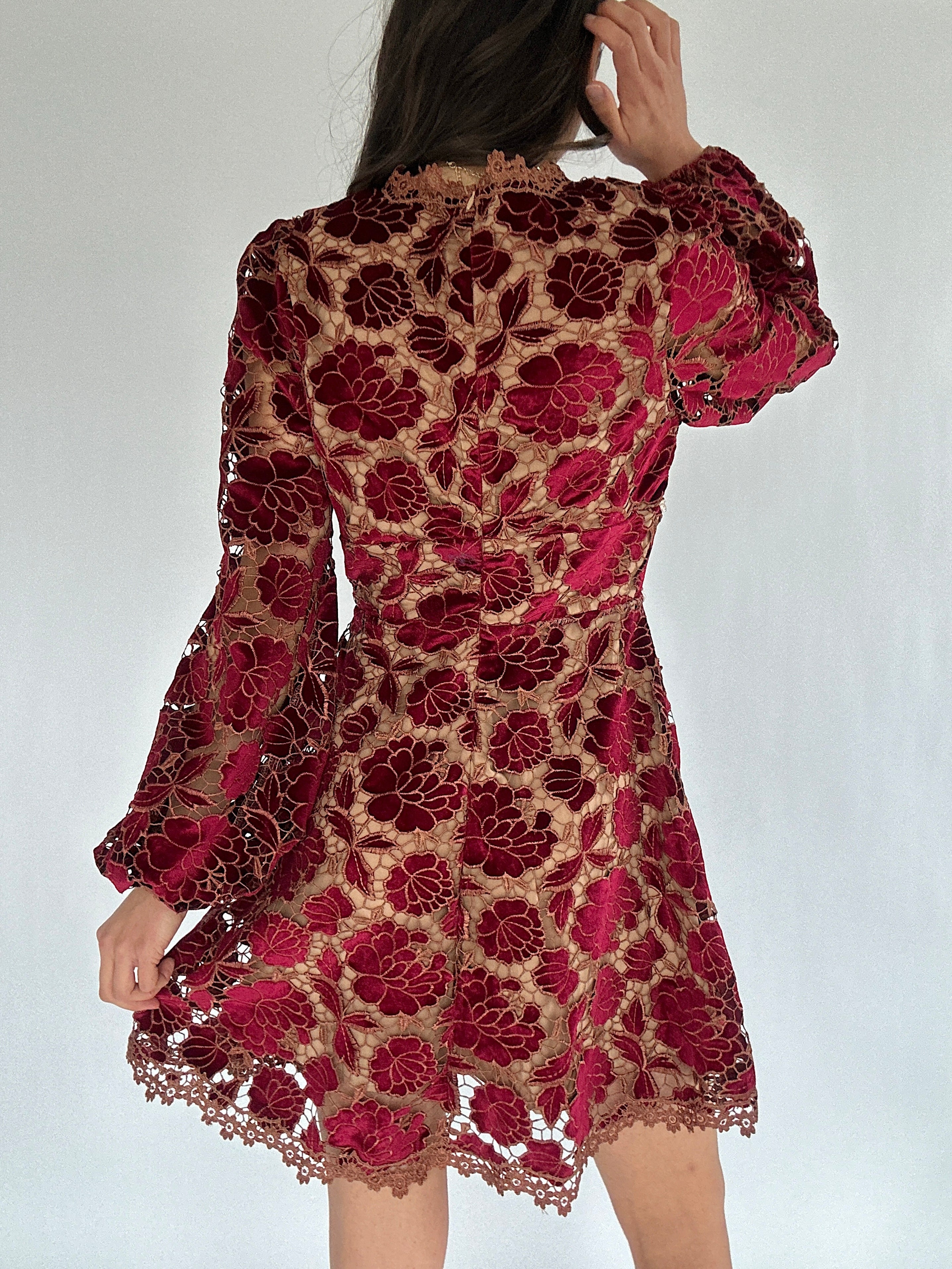 Red lace dress on a white background showing back zipper