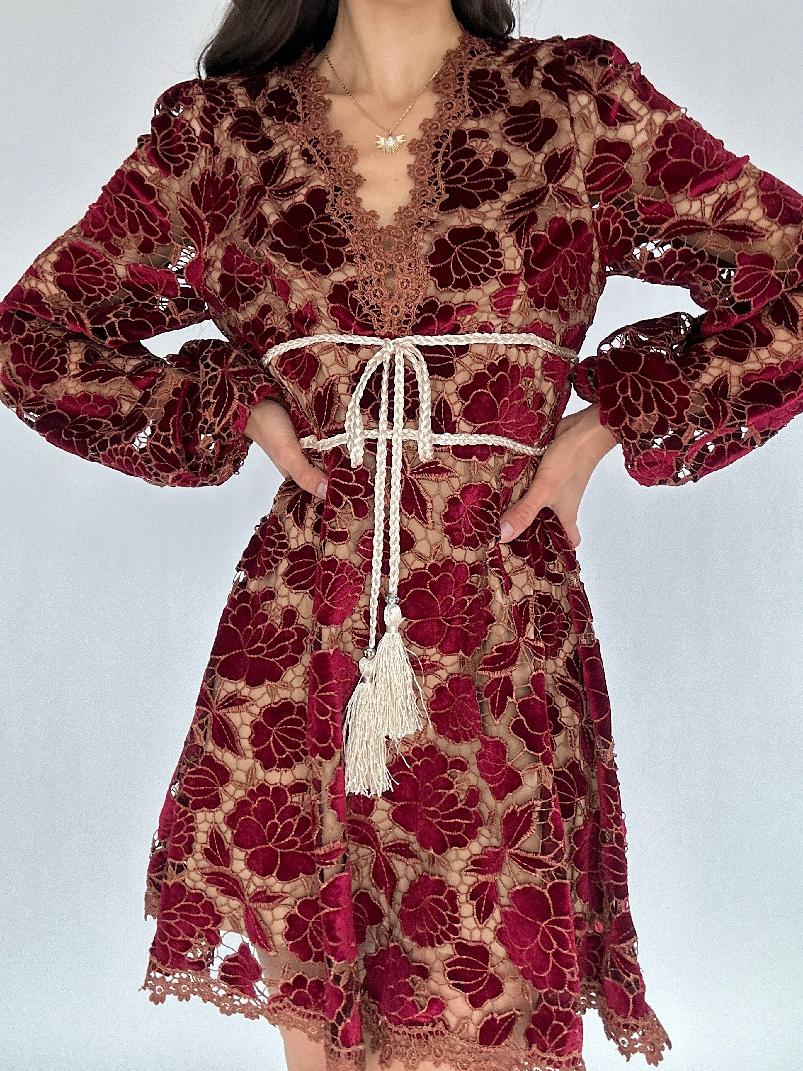 Red and brown floral lace dress with long sleeves on a white background
