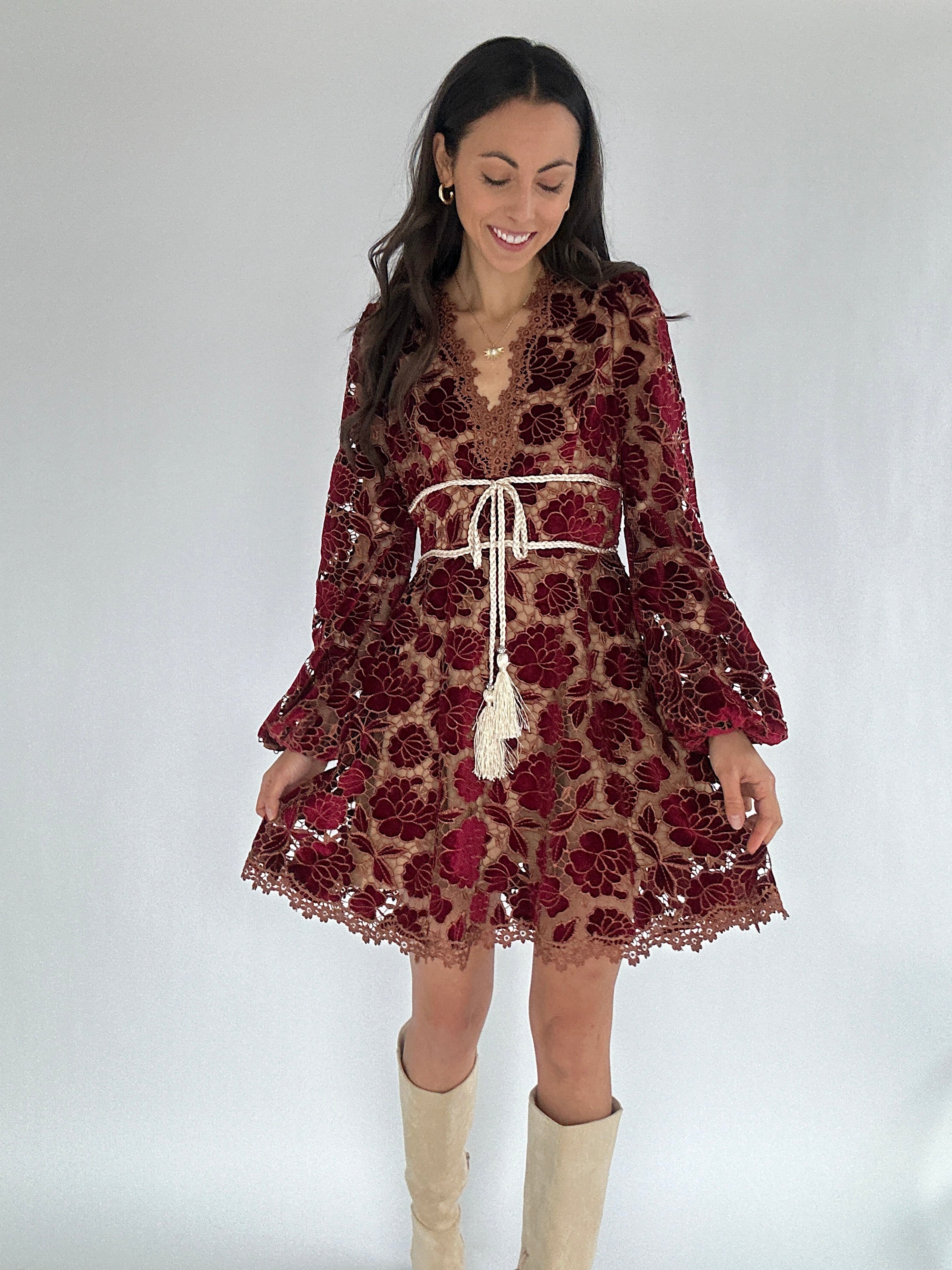 Woman wearing a floral dress with long sleeves on a white background
