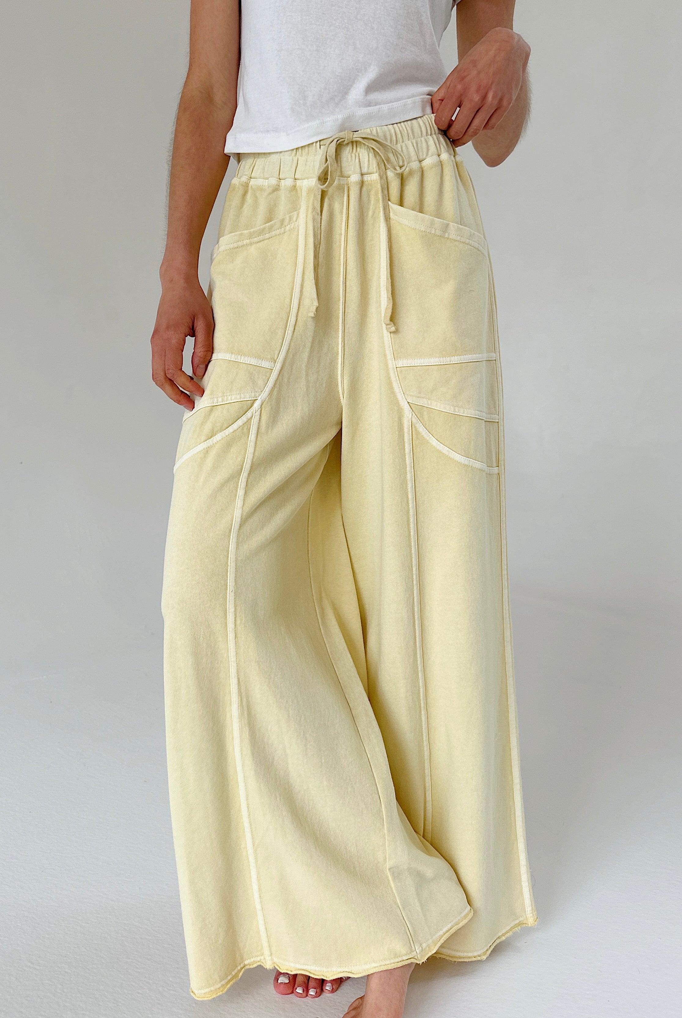 Light yellow wide-leg pants worn by a person on a plain background