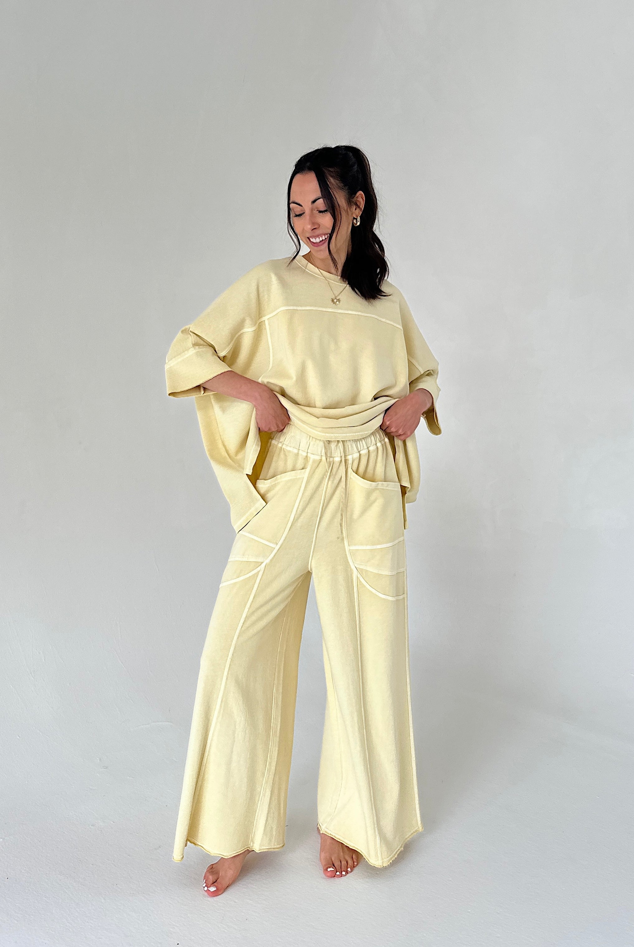 Woman wearing a light yellow outfit on a plain background