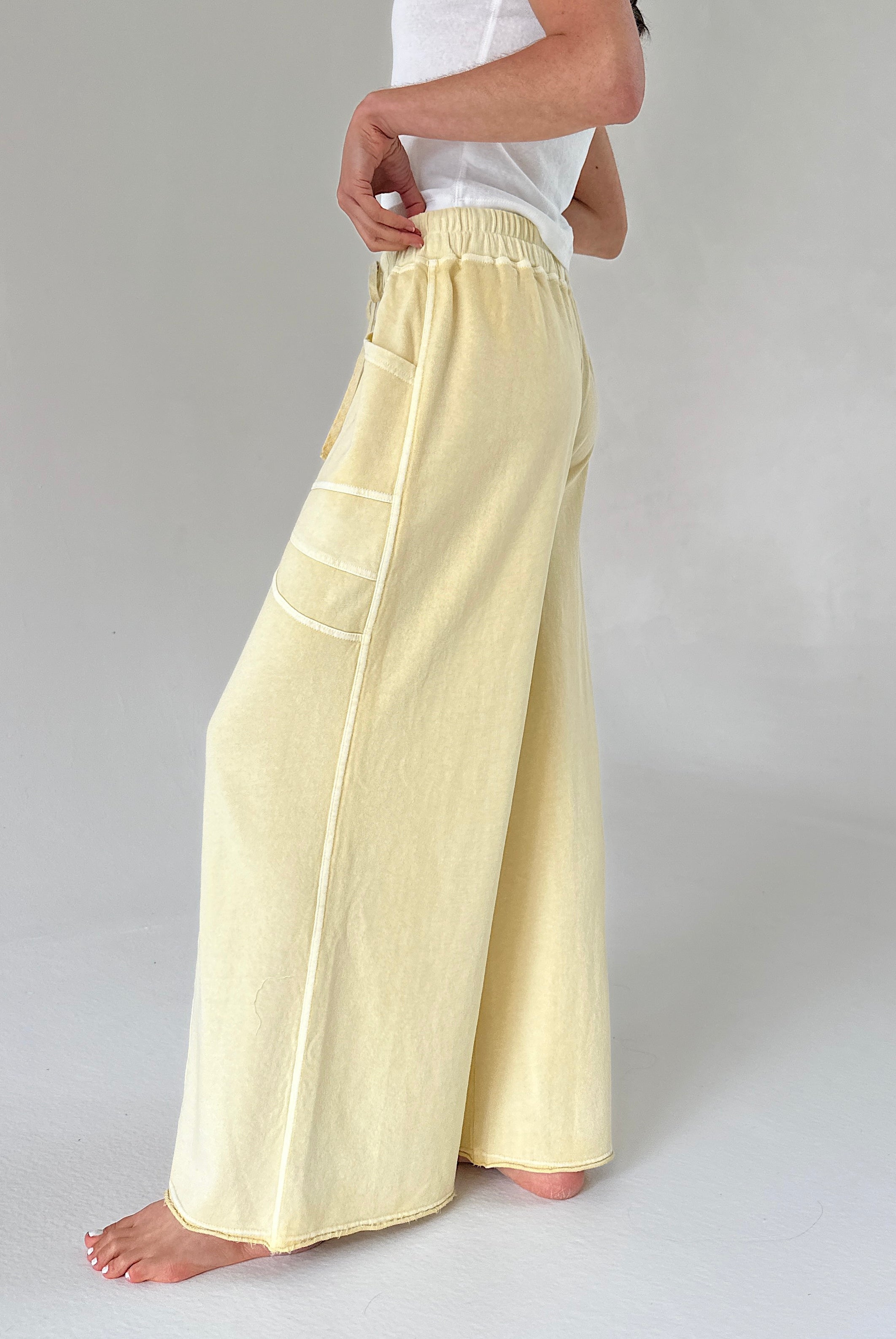 Person wearing light yellow wide-leg pants on a plain background