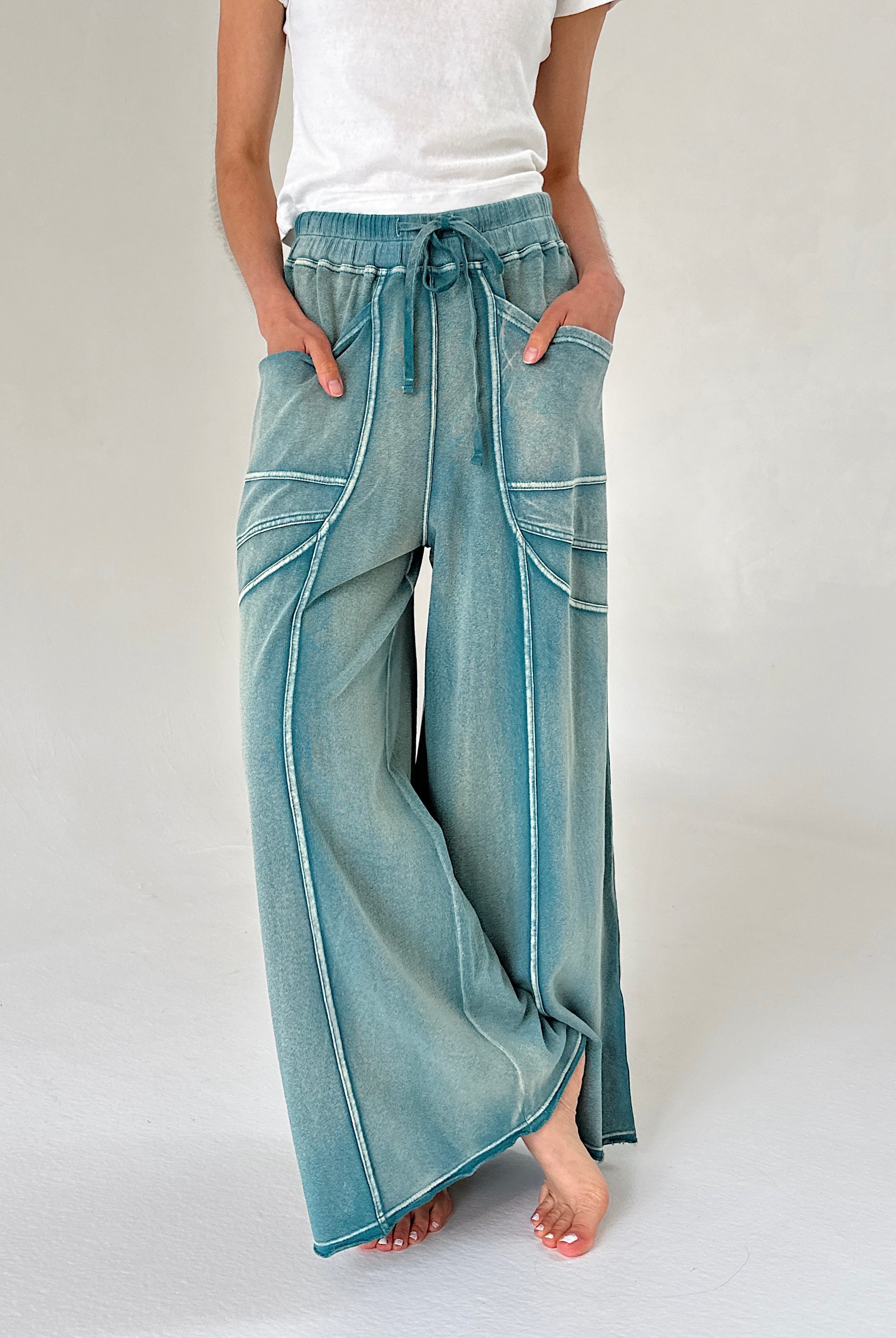 Person wearing teal wide-leg pants on a plain background