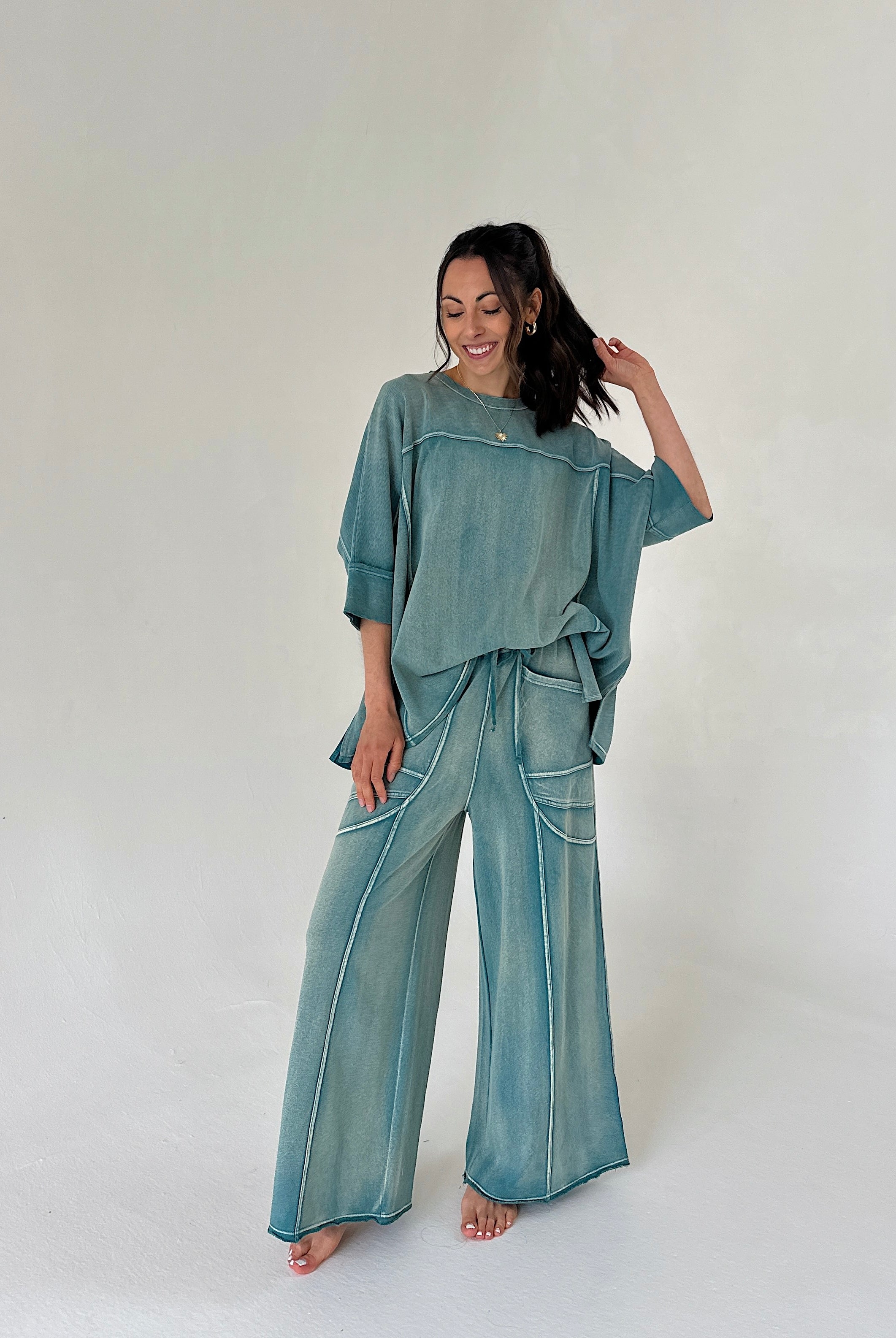Woman wearing a teal outfit on a white background