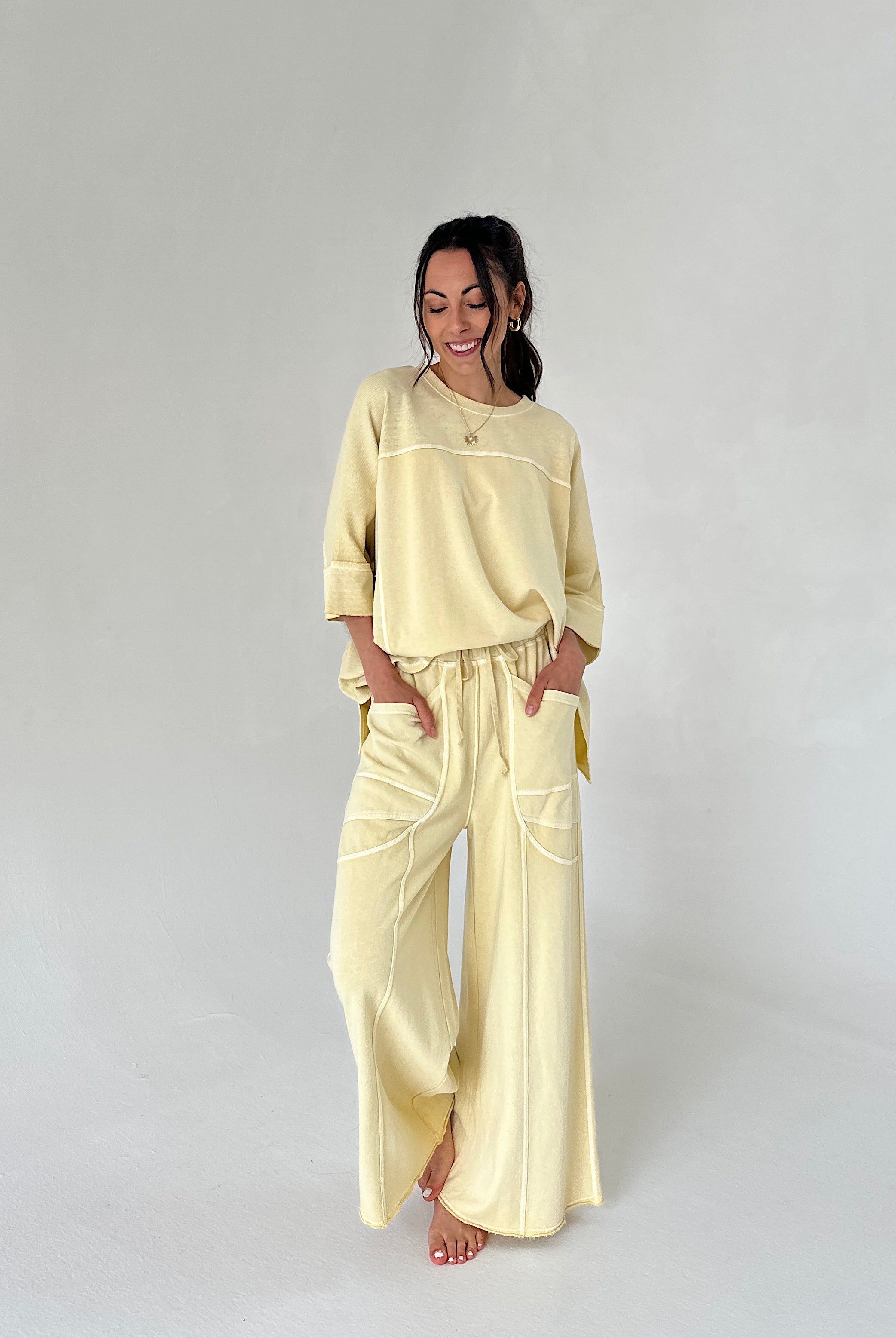 Woman wearing a light yellow outfit on a plain background