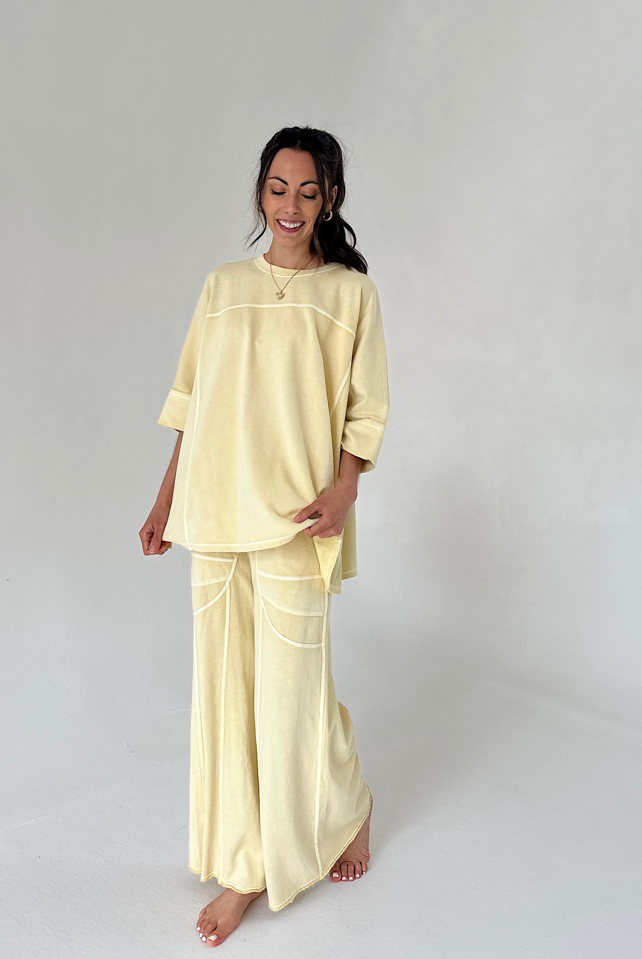 Woman wearing a light yellow outfit on a plain background