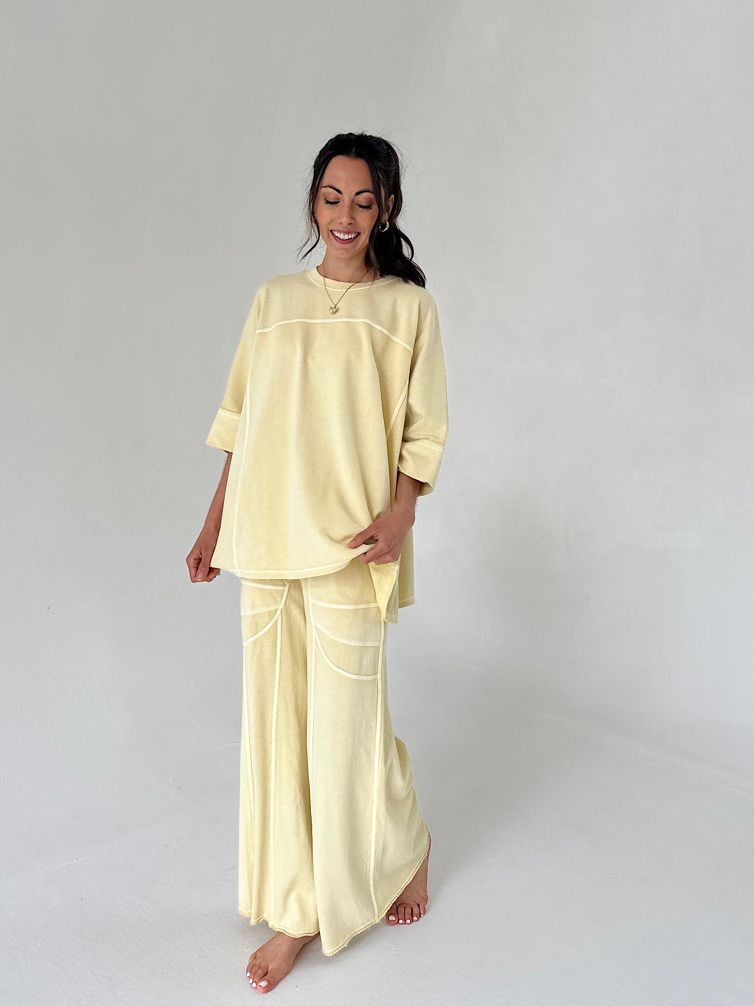 Woman wearing a light yellow outfit on a plain background