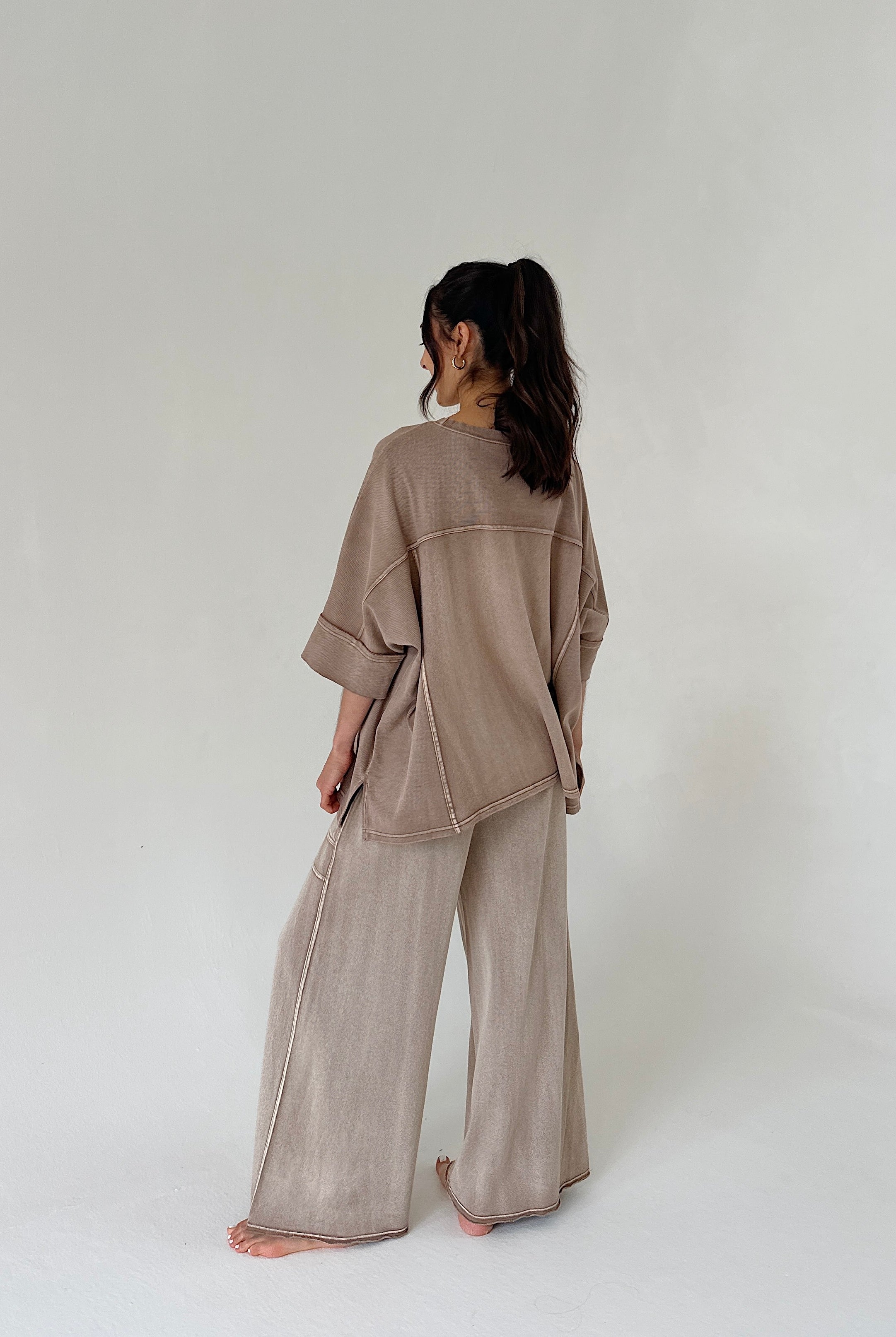 Person wearing a beige outfit on a white background