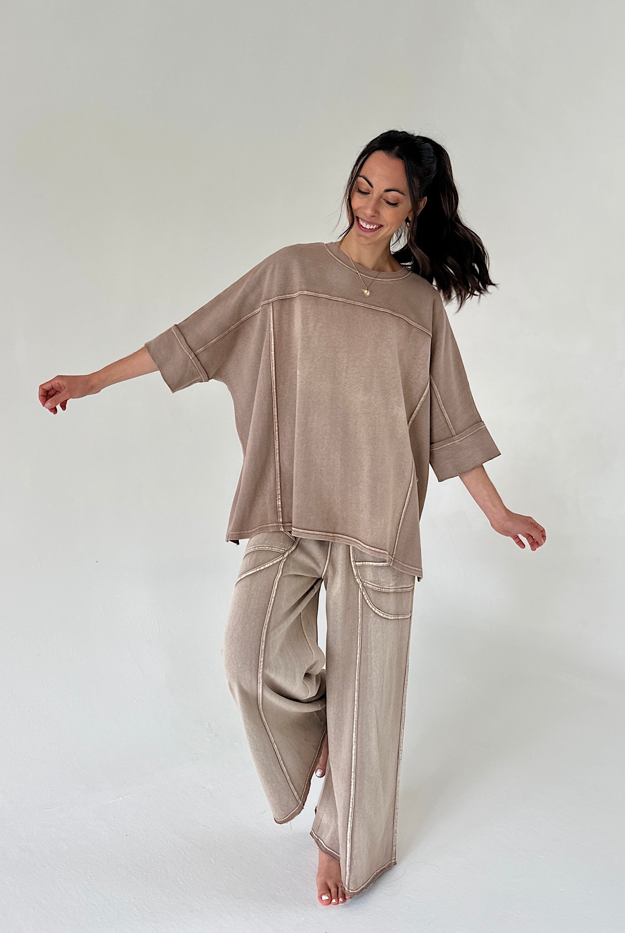 Woman wearing a camel brown matching outfit on a white background
