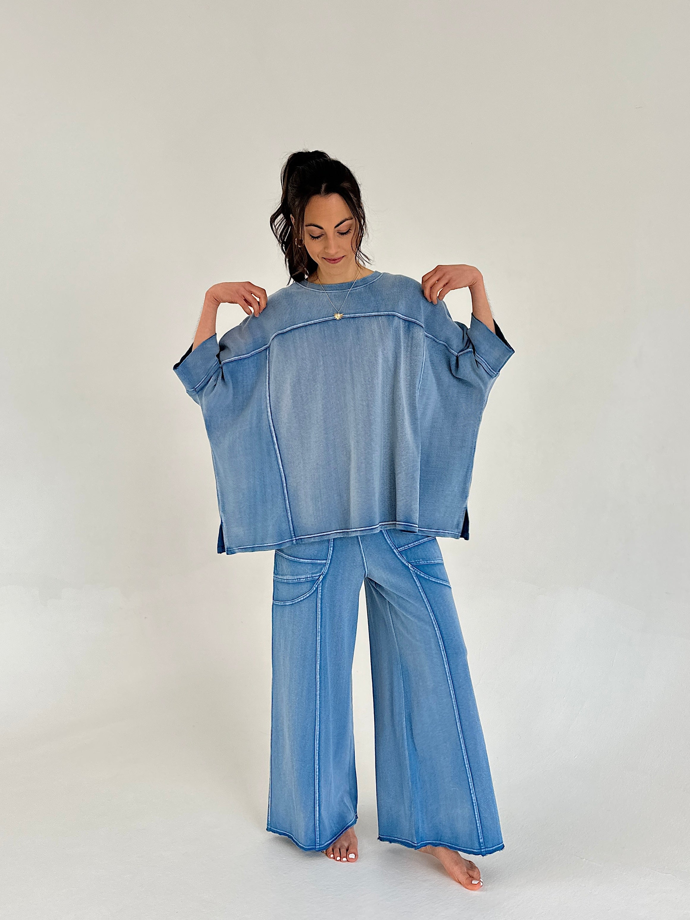 Woman wearing a blue lounge outfit on a plain background