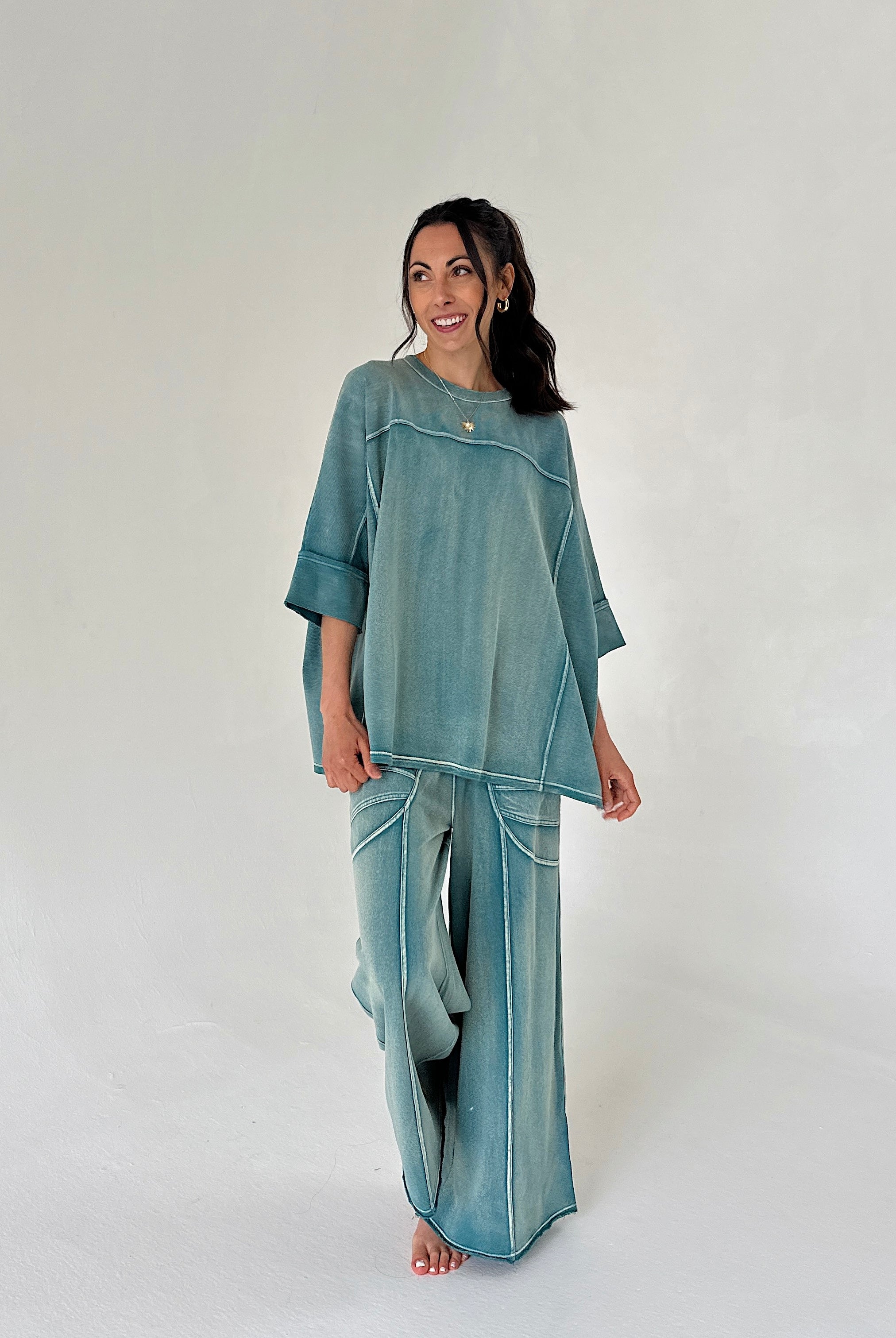Woman wearing a teal outfit on a white background
