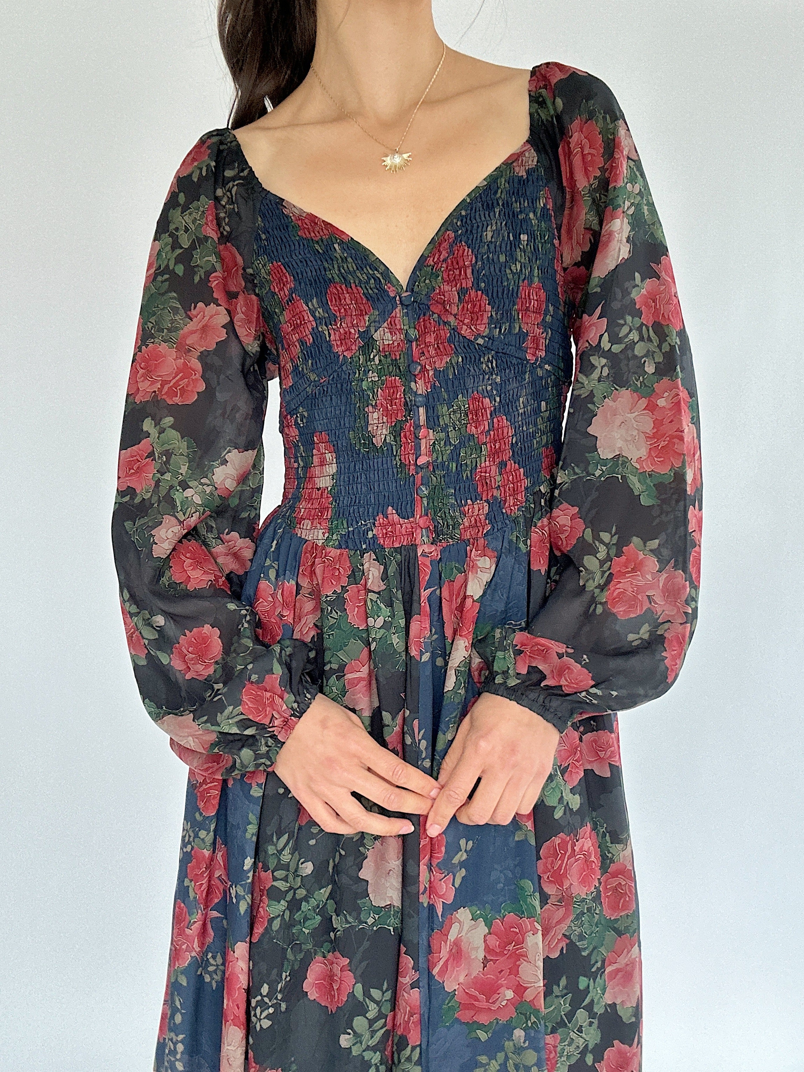 Floral dress with long sleeves on a plain background showing smocked top and sweetheart neckline
