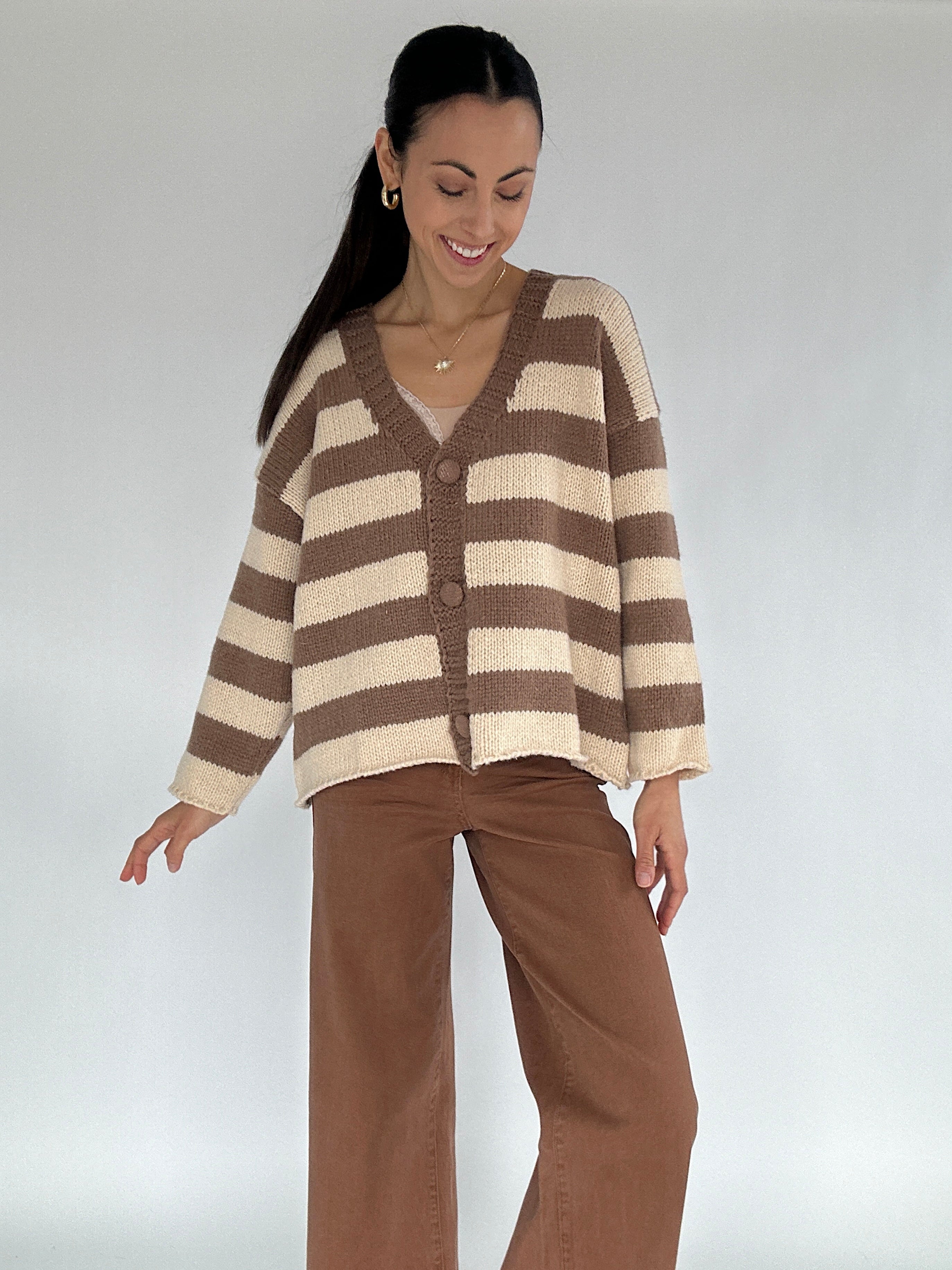 Woman wearing a brown and beige striped cardigan against a white background