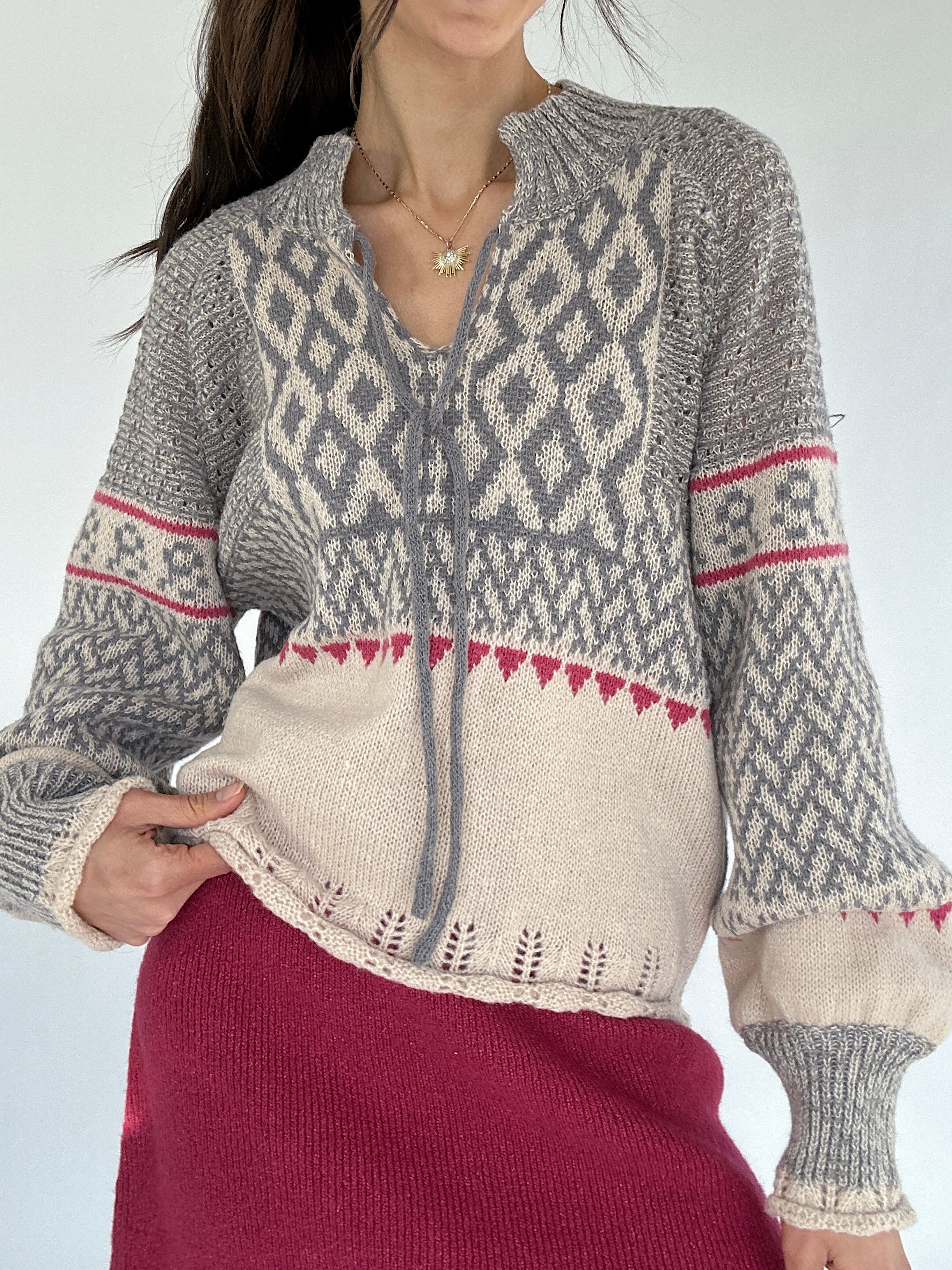Person wearing a nordic patterned sweater with a plain background