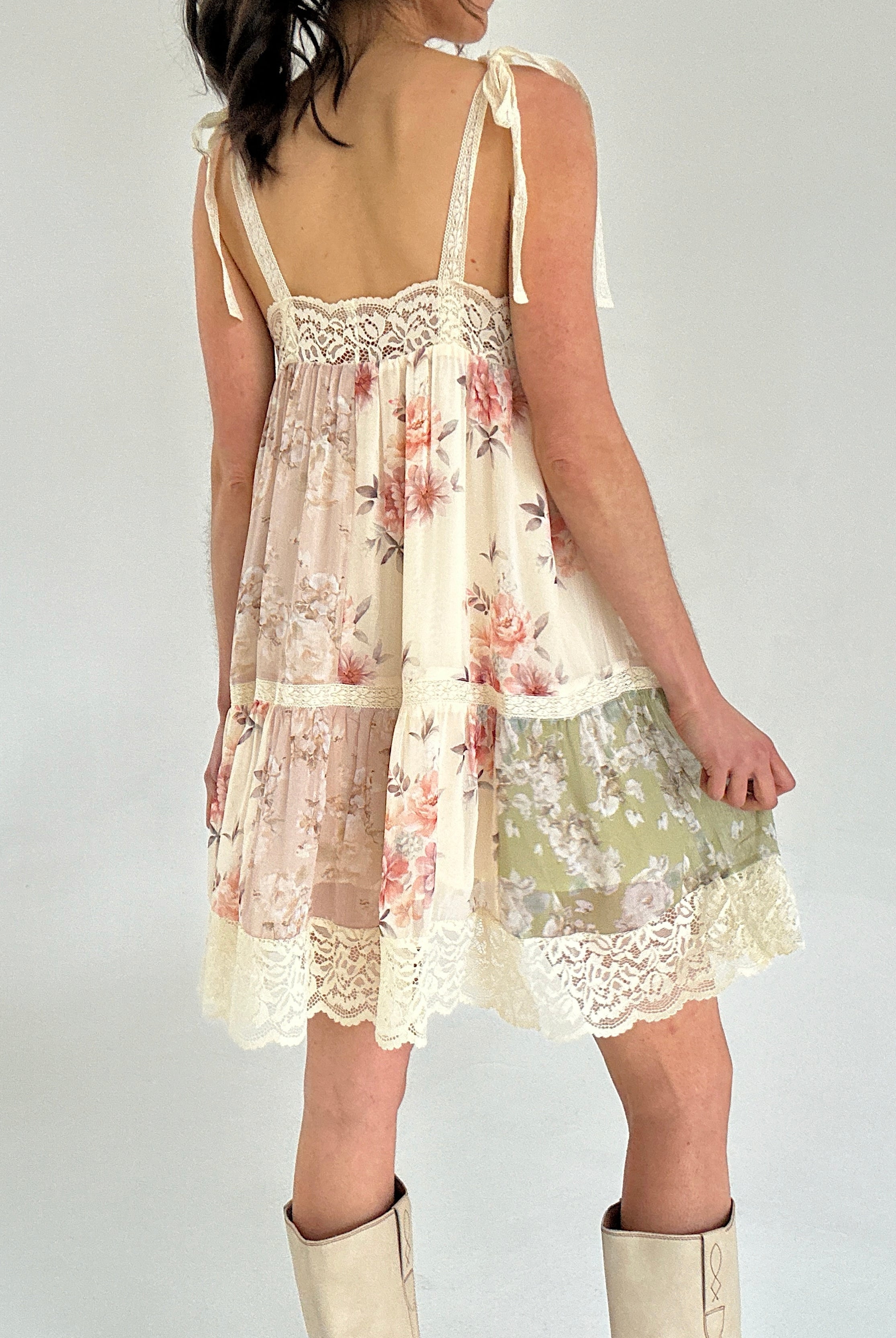 Floral dress with lace details on a plain background showing back