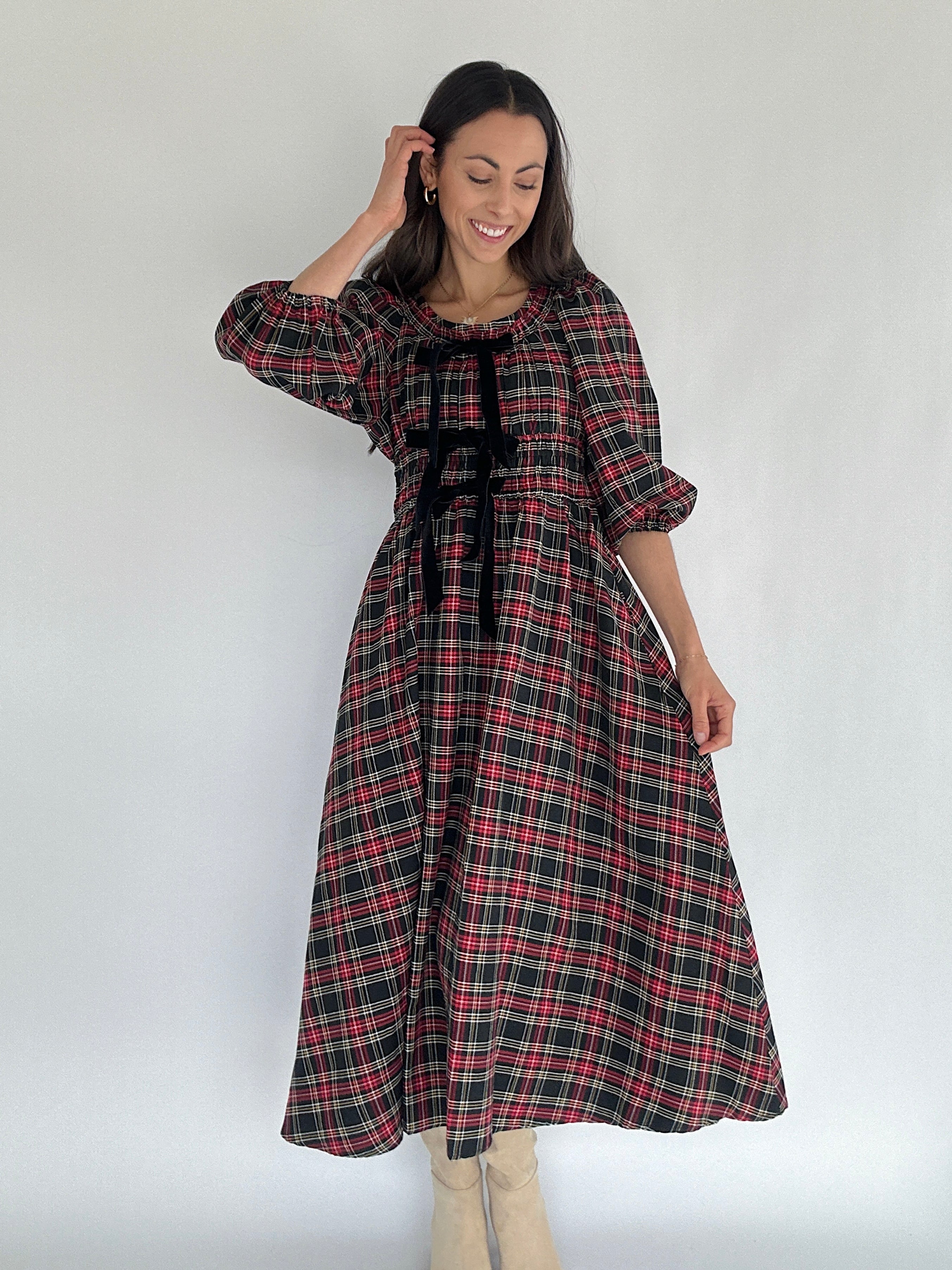 Woman wearing a plaid dress with a plain background