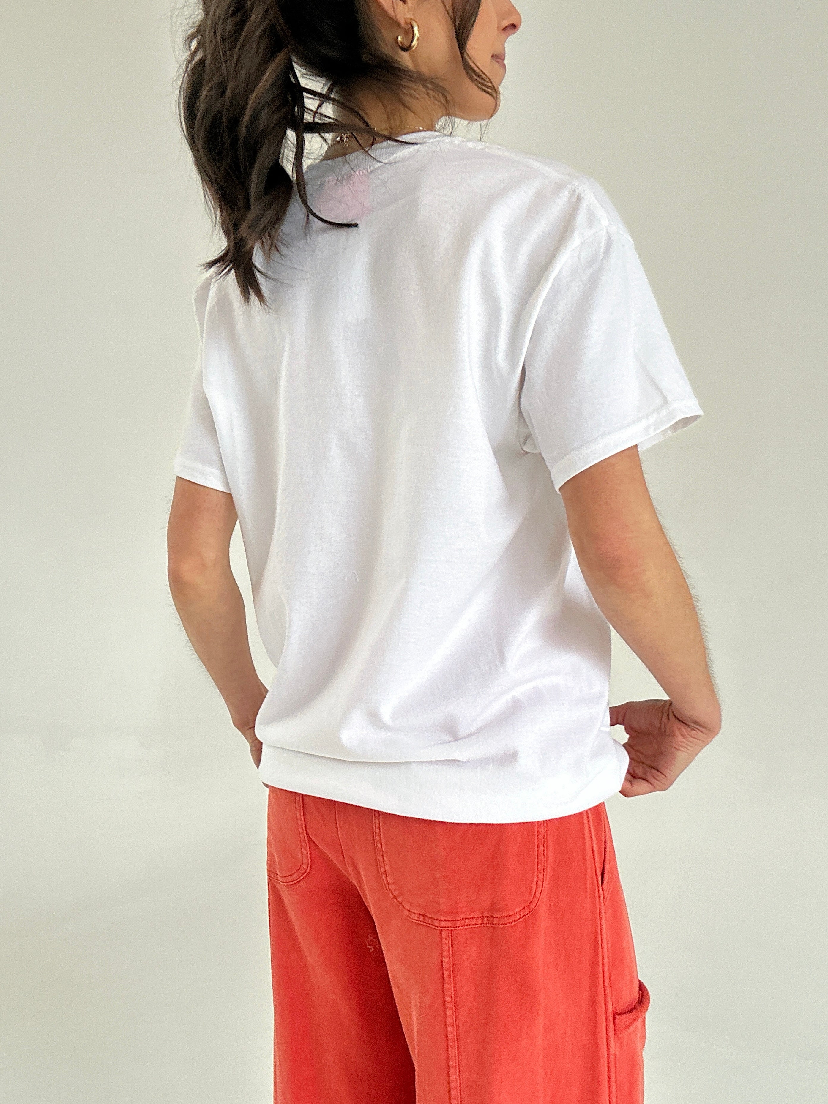 Person wearing a white t-shirt and red pants on a plain background