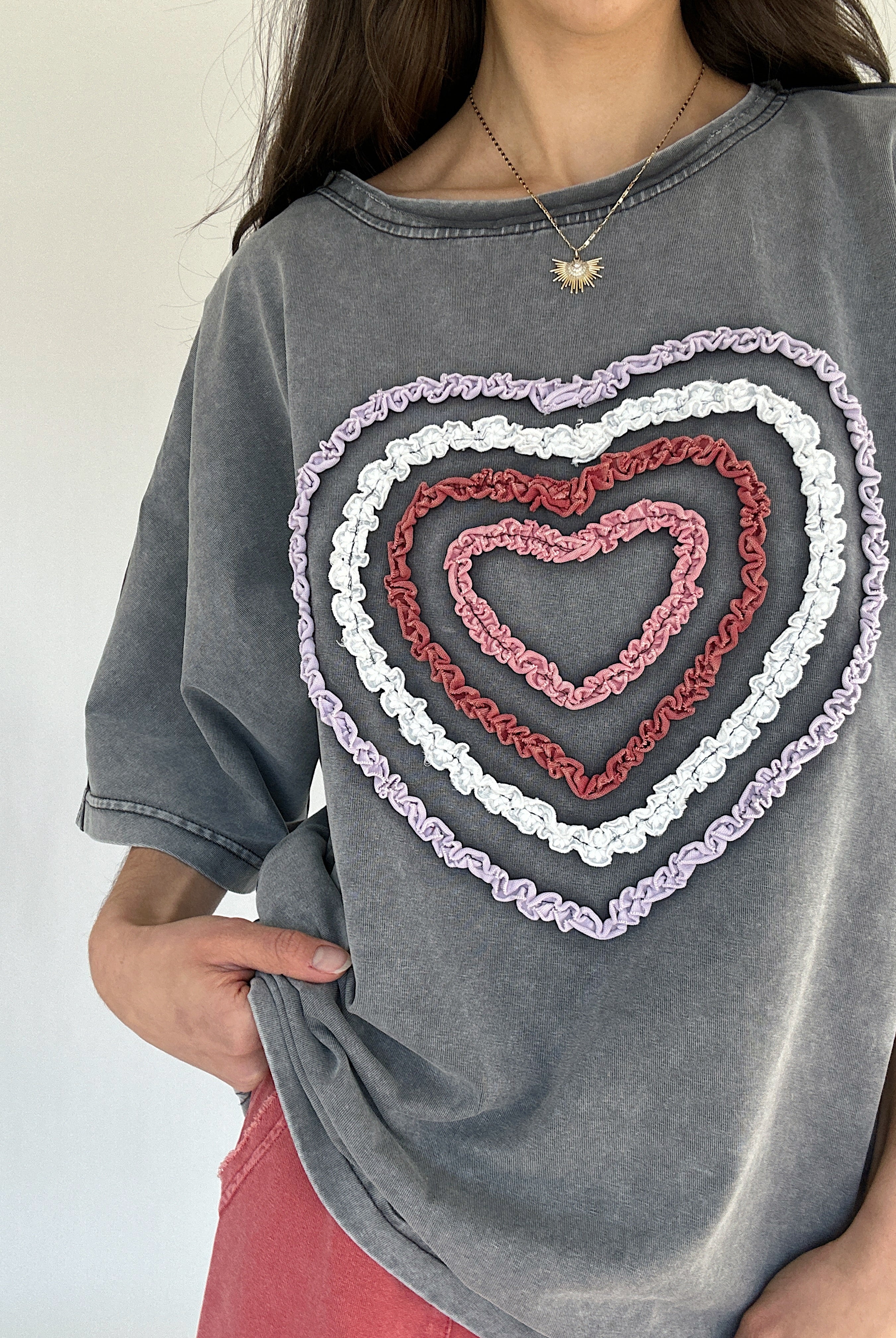Gray t-shirt with a colorful textured heart design on a plain background