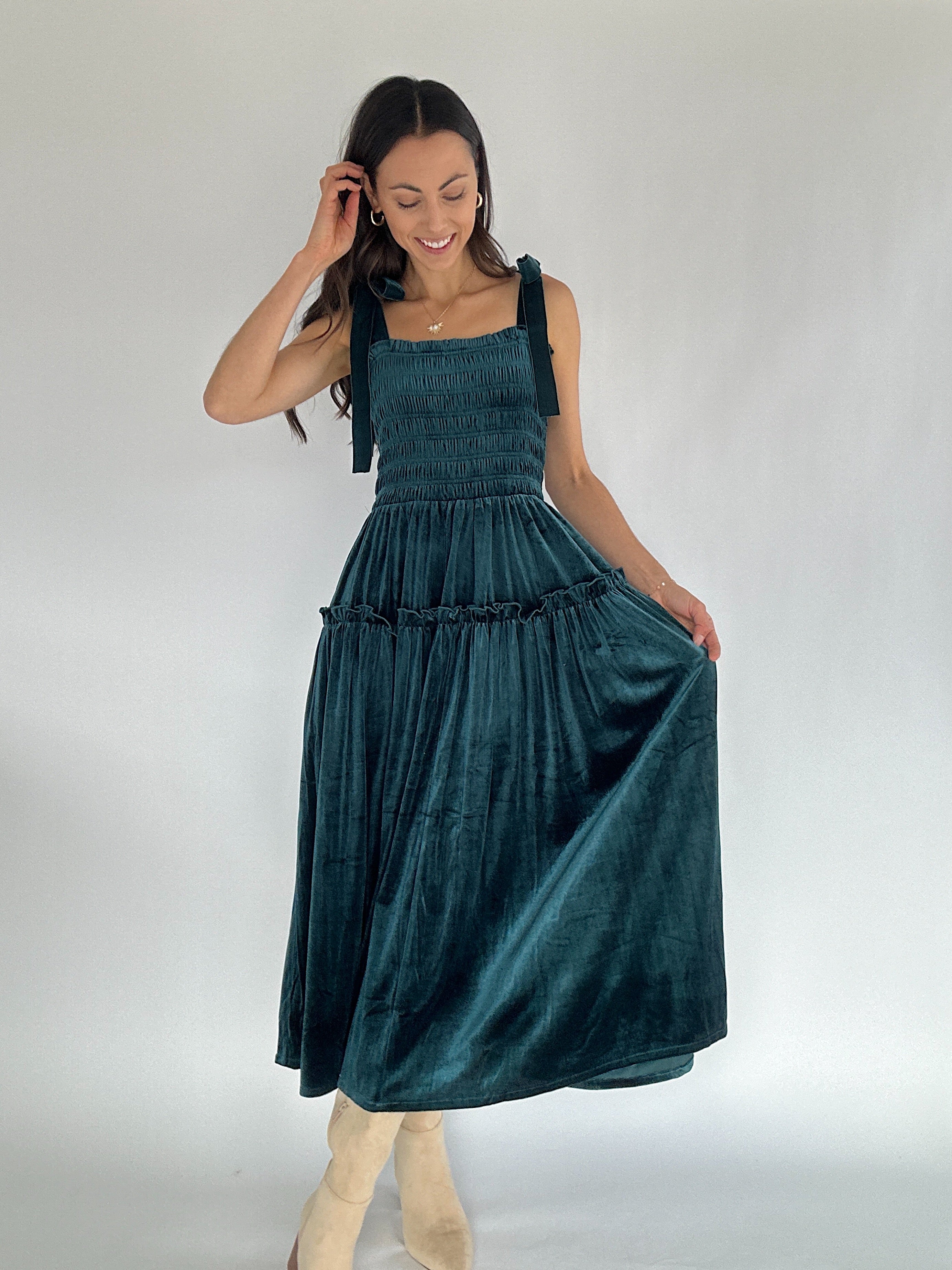 Woman wearing teal velvet midi dress