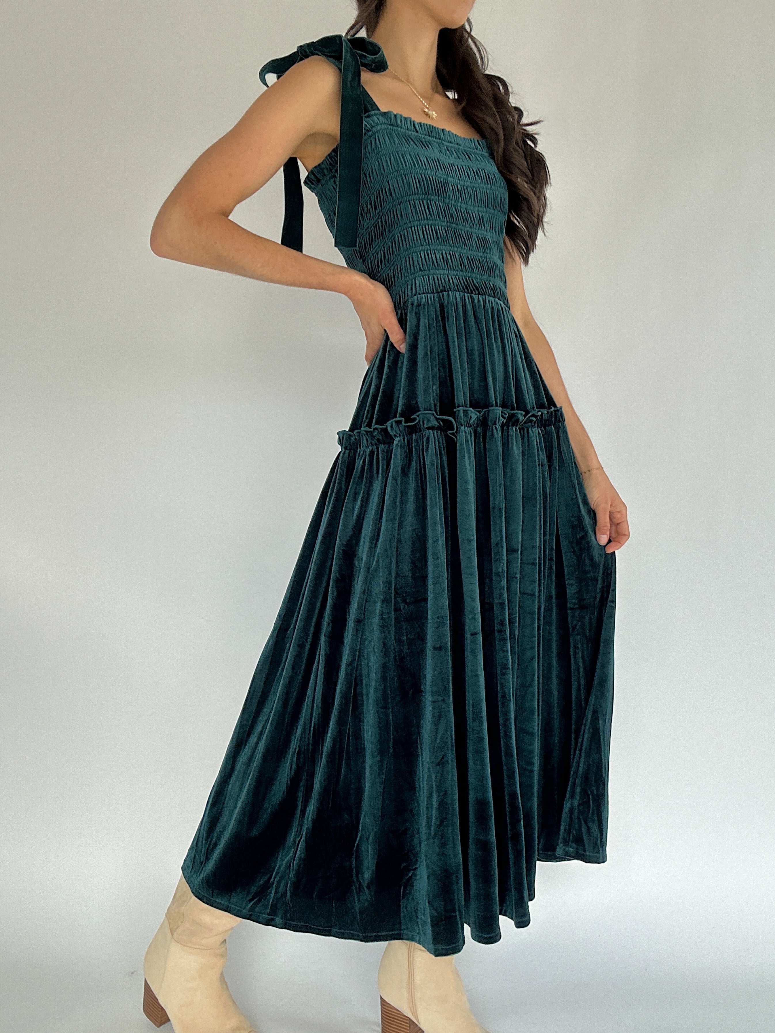 Woman wearing a green dress against a plain background