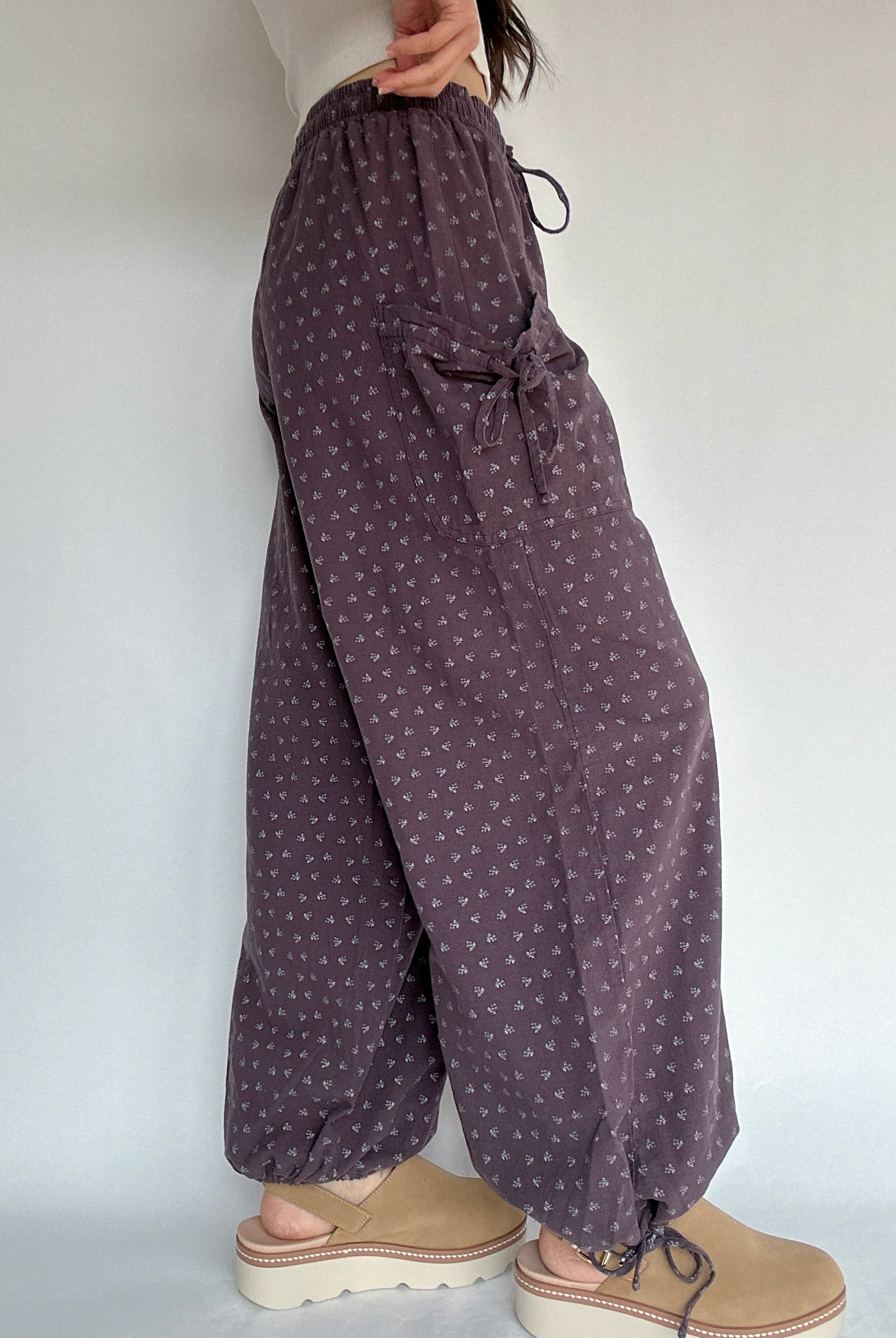 Purple patterned pants worn by a person on a white background showing side detail