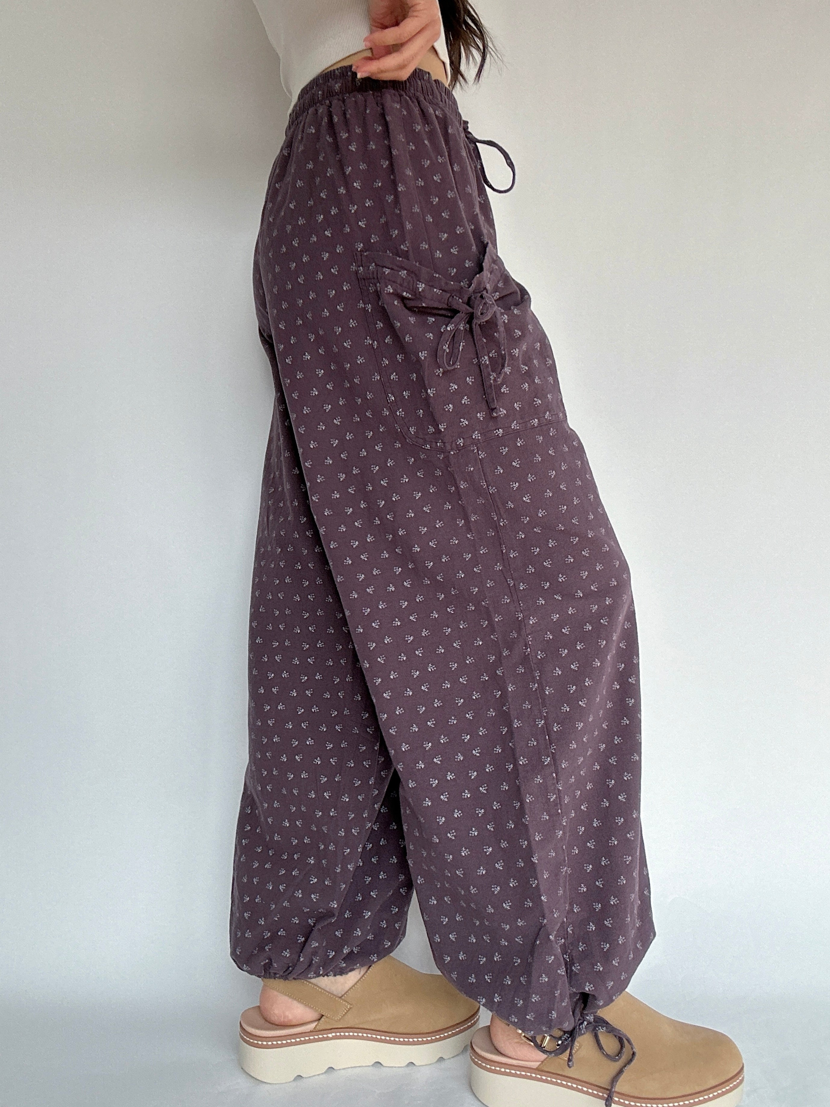 Purple patterned pants worn by a person on a white background showing side detail