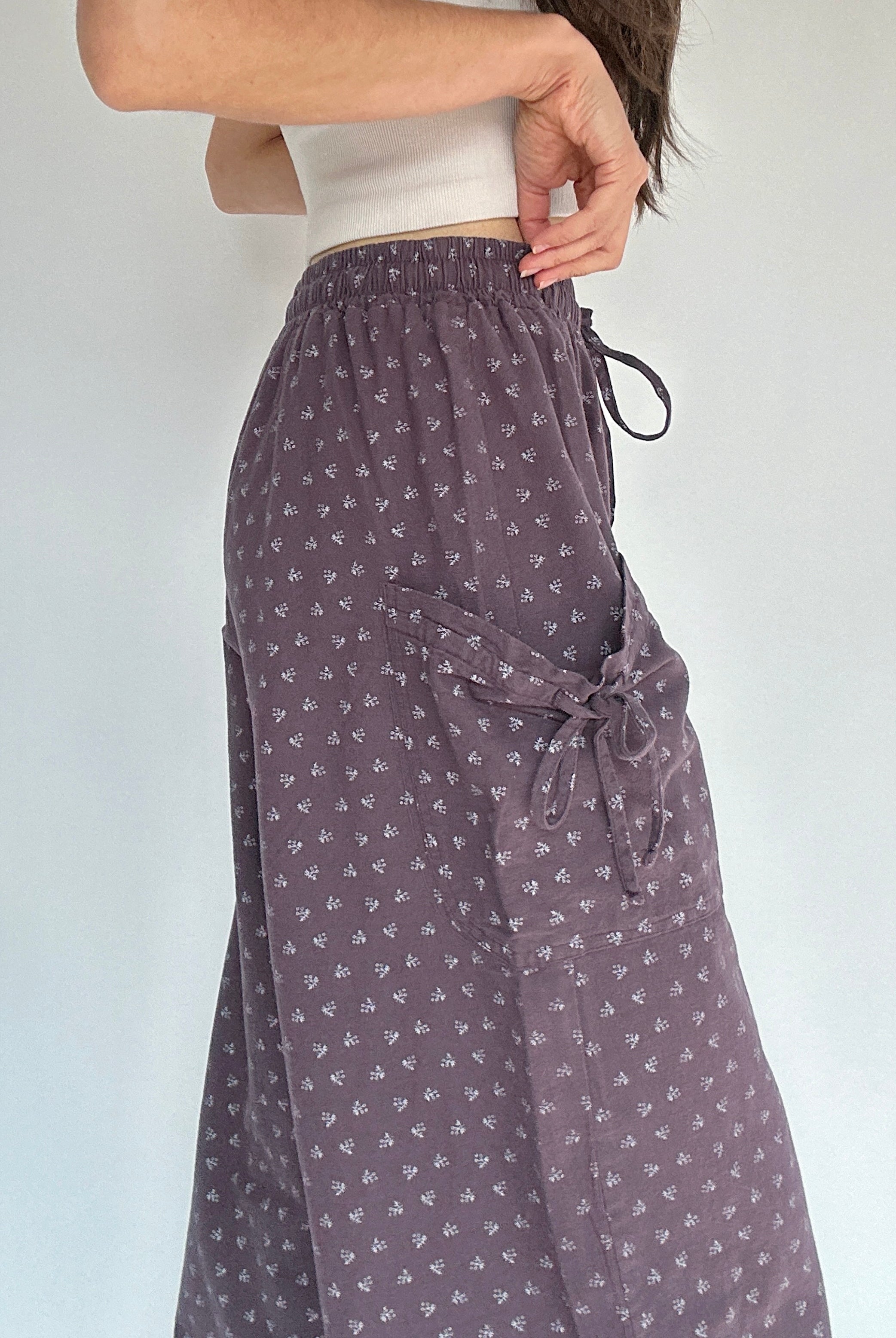 Person wearing a patterned purple pants showing the side pocket detail