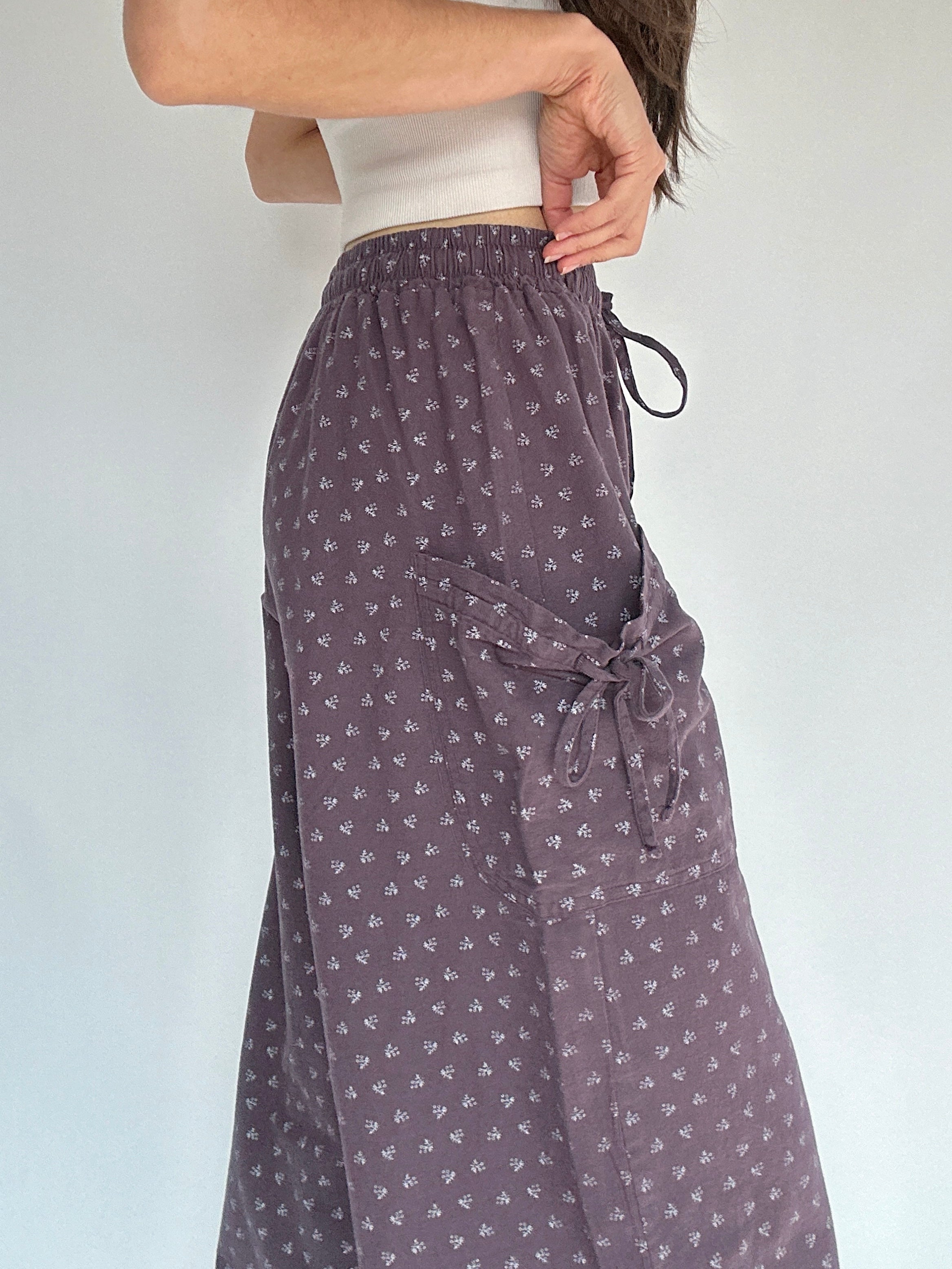 Person wearing a patterned purple pants showing the side pocket detail