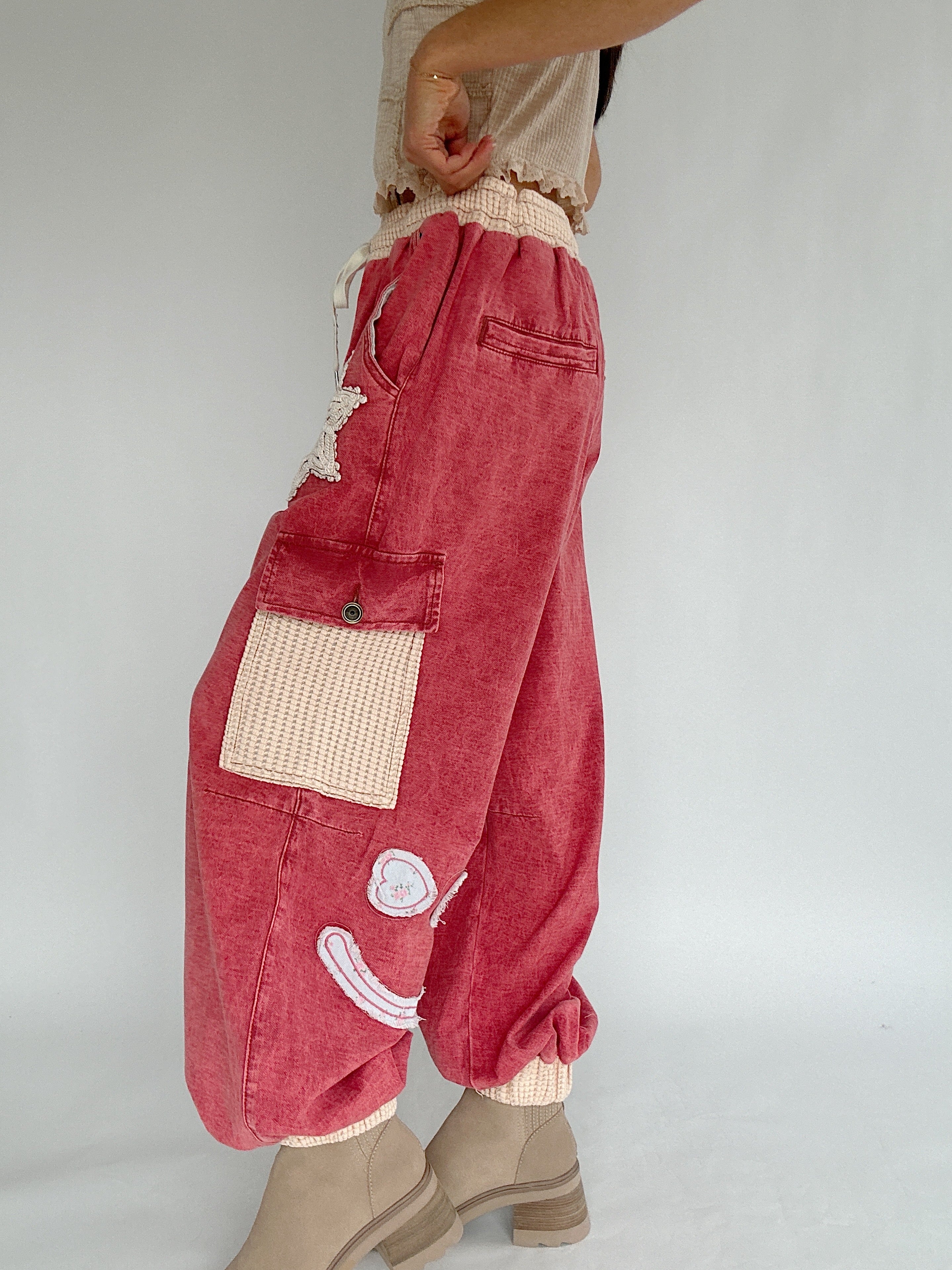 Red patchwork pants with decorative elements on a plain background