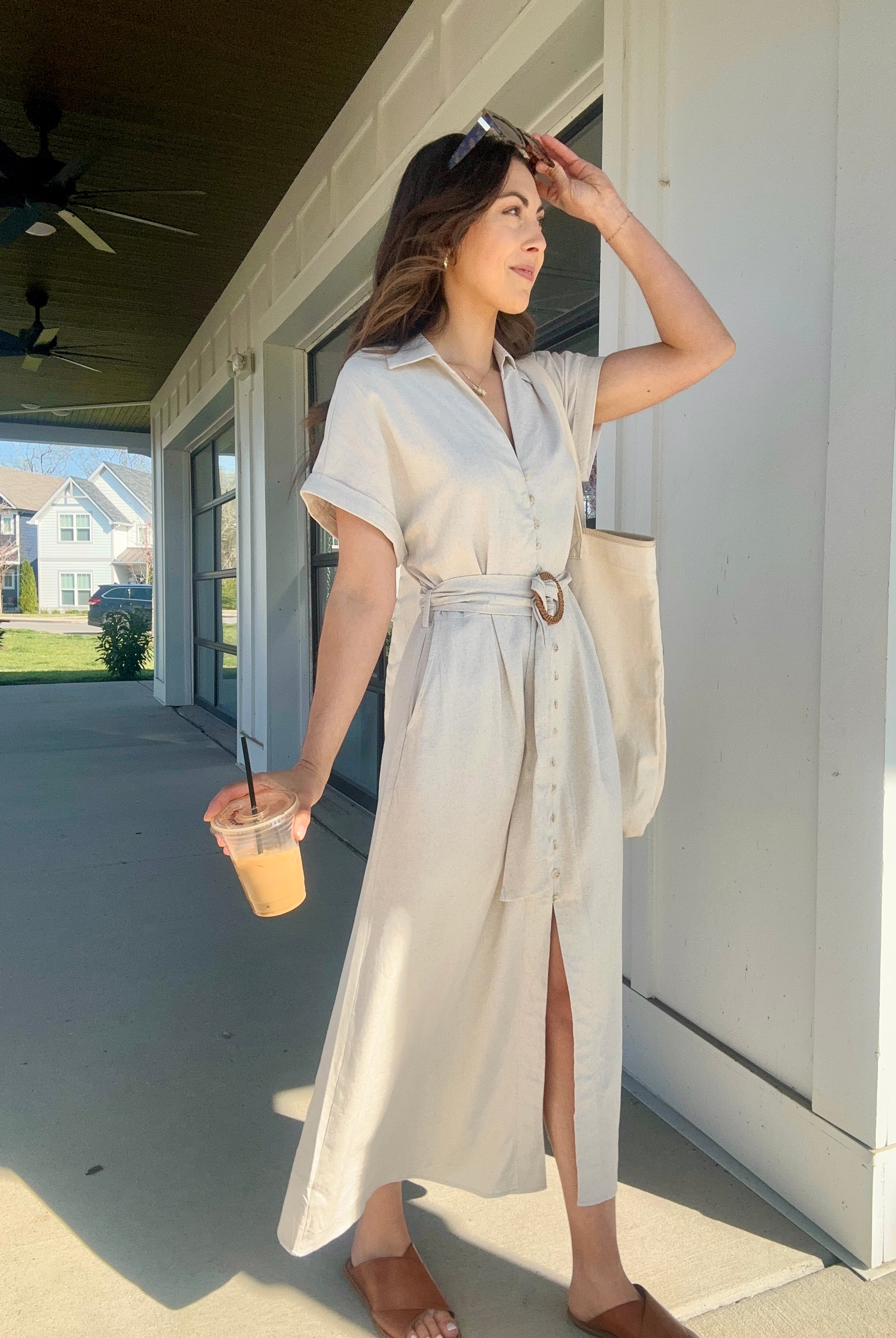 Woman wearing an oatmeal linen maxi dress carrying a coffee
