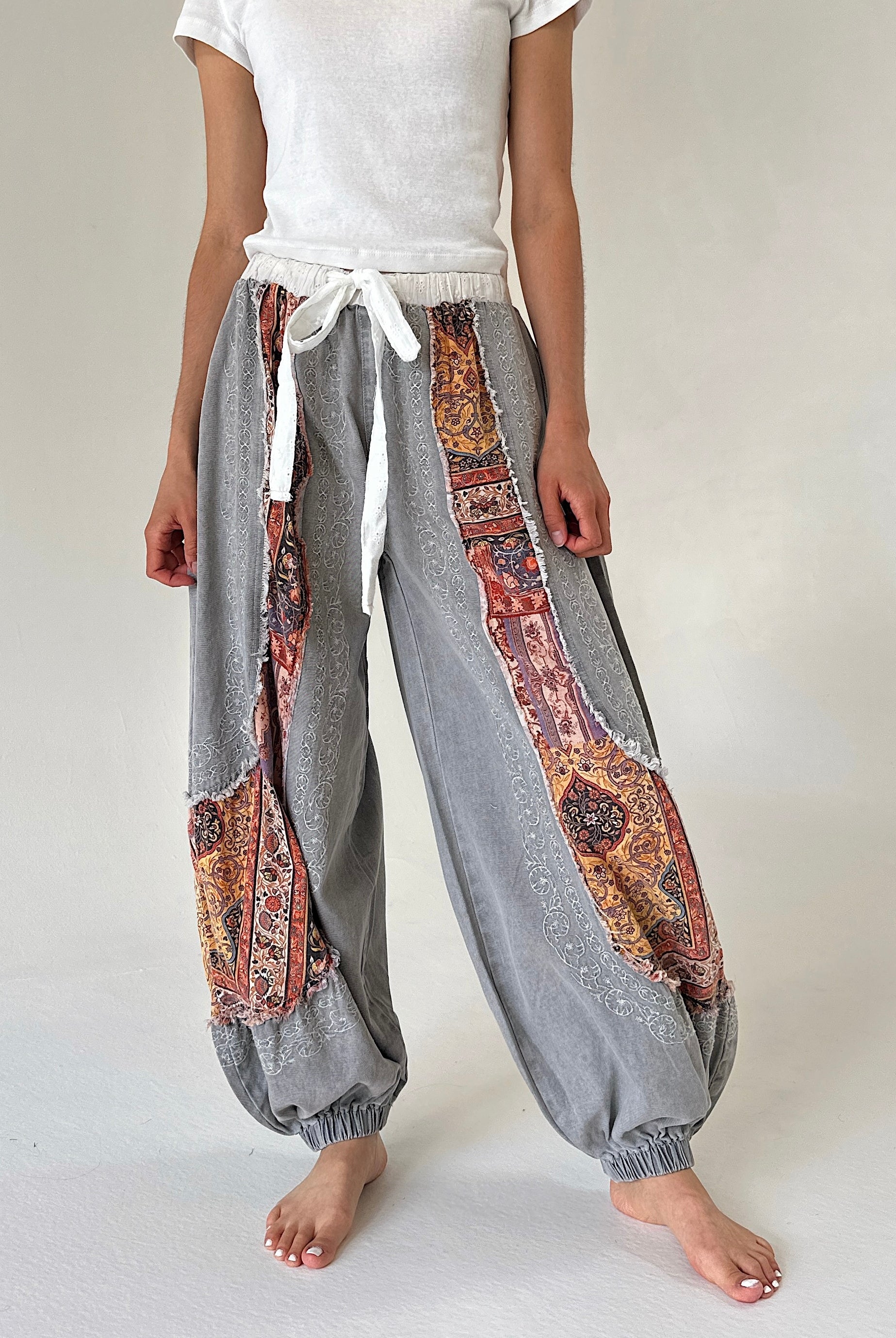 Grey joggers with floral accents and white drawstring