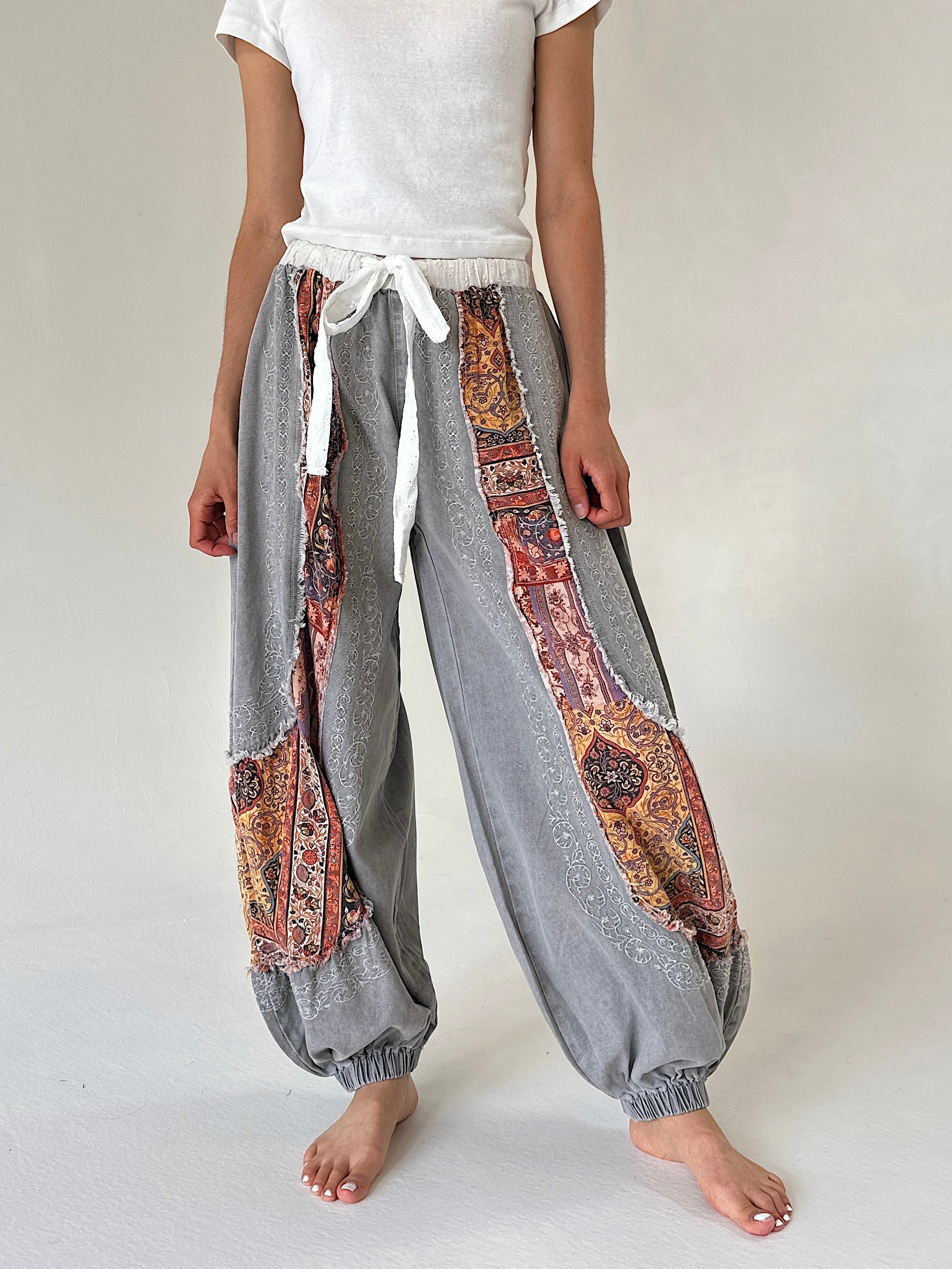 Grey joggers with floral accents and white drawstring