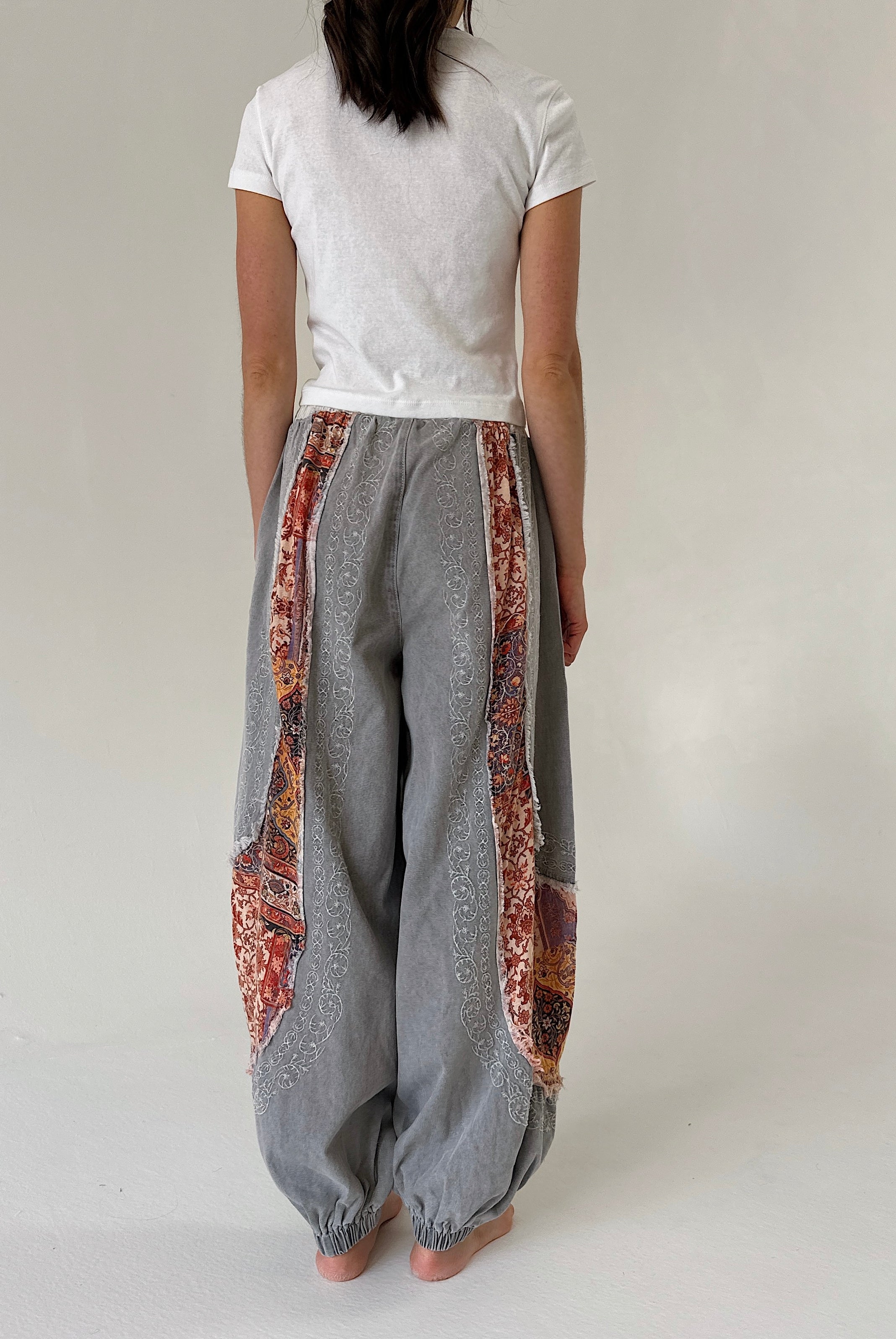 woman wearing charcoal jogger pants with floral accents from the back