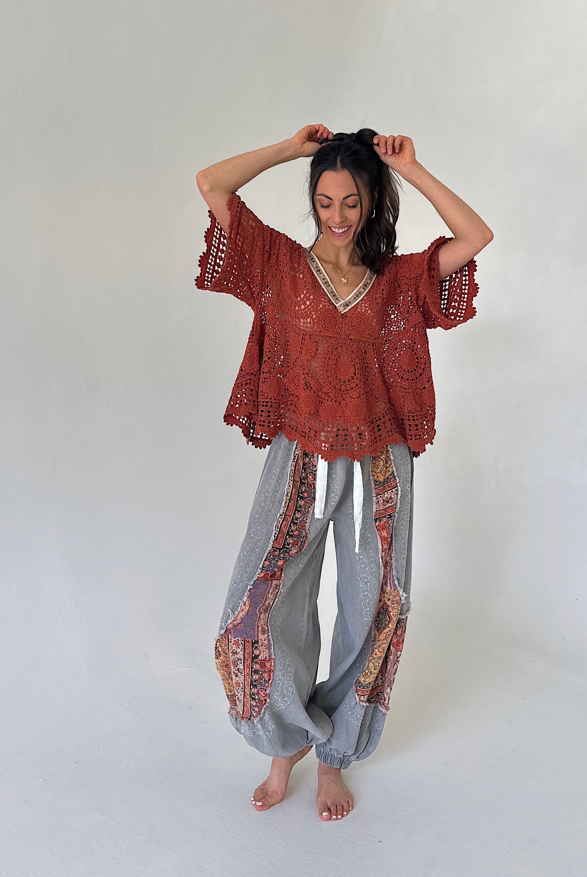 woman wearing a rust knit short sleeve top and grey jogger pants
