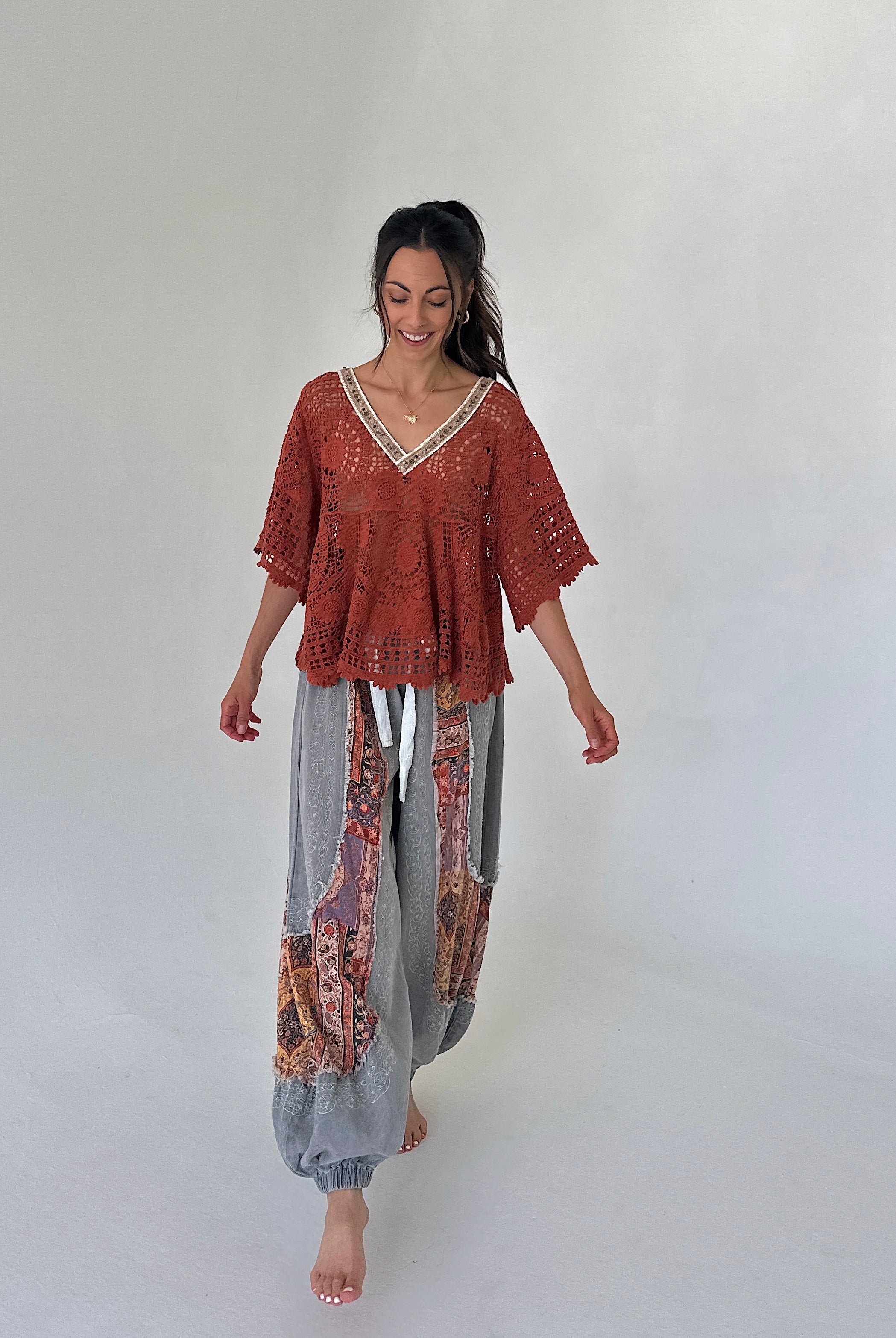 woman wearing a rust top with charcoal jogger pants